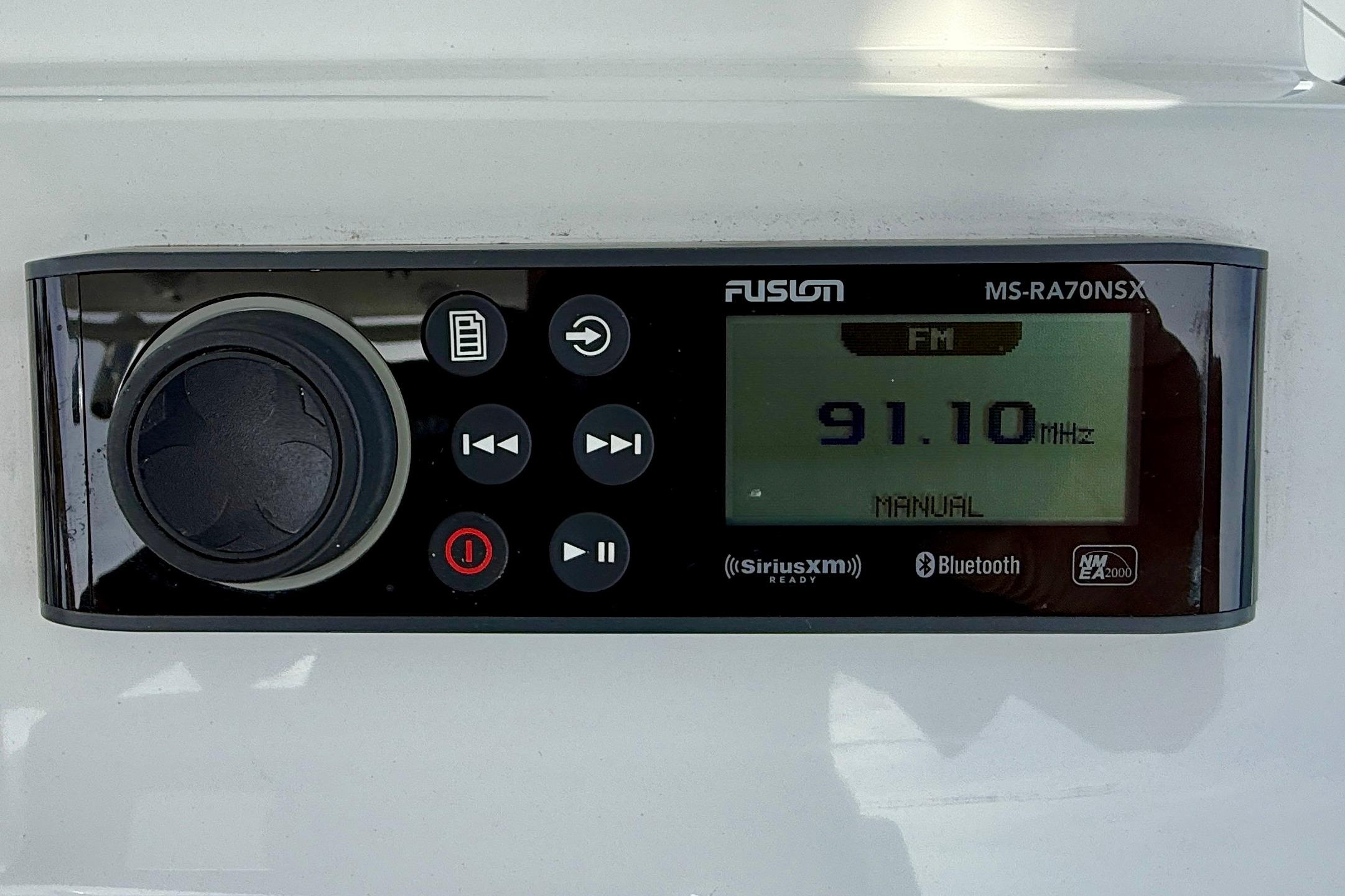Fusion MS-RA70NSX stereo system displaying FM 91.10 MHz, on Edgewater 245CC 2023 boat.