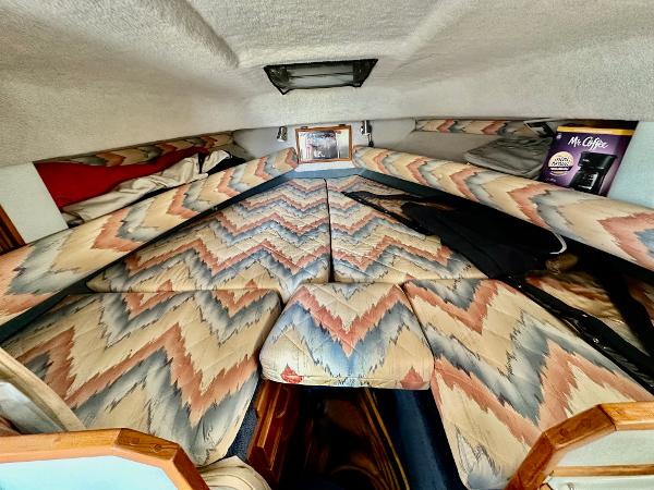 1987 Sea Ray 270 Sundancer cabin with patterned upholstery and cozy sleeping area.