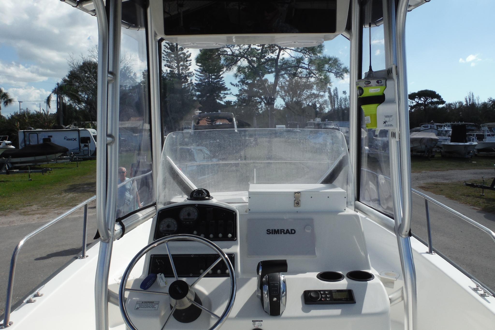 2015 Boston Whaler 210 Montauk boat cockpit with steering wheel and Simrad navigation system.