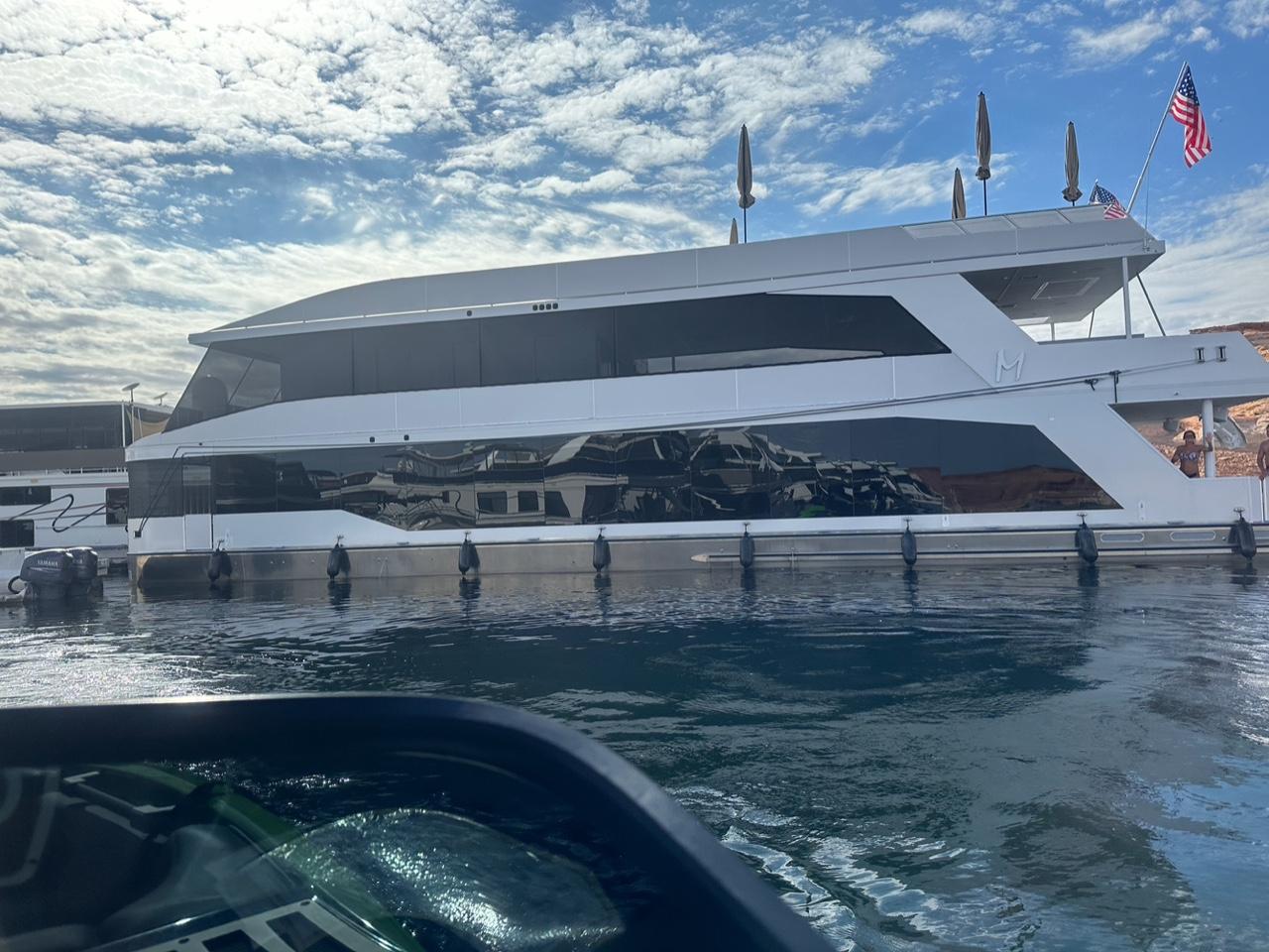 Luxury yacht Adonia on calm water under blue sky.