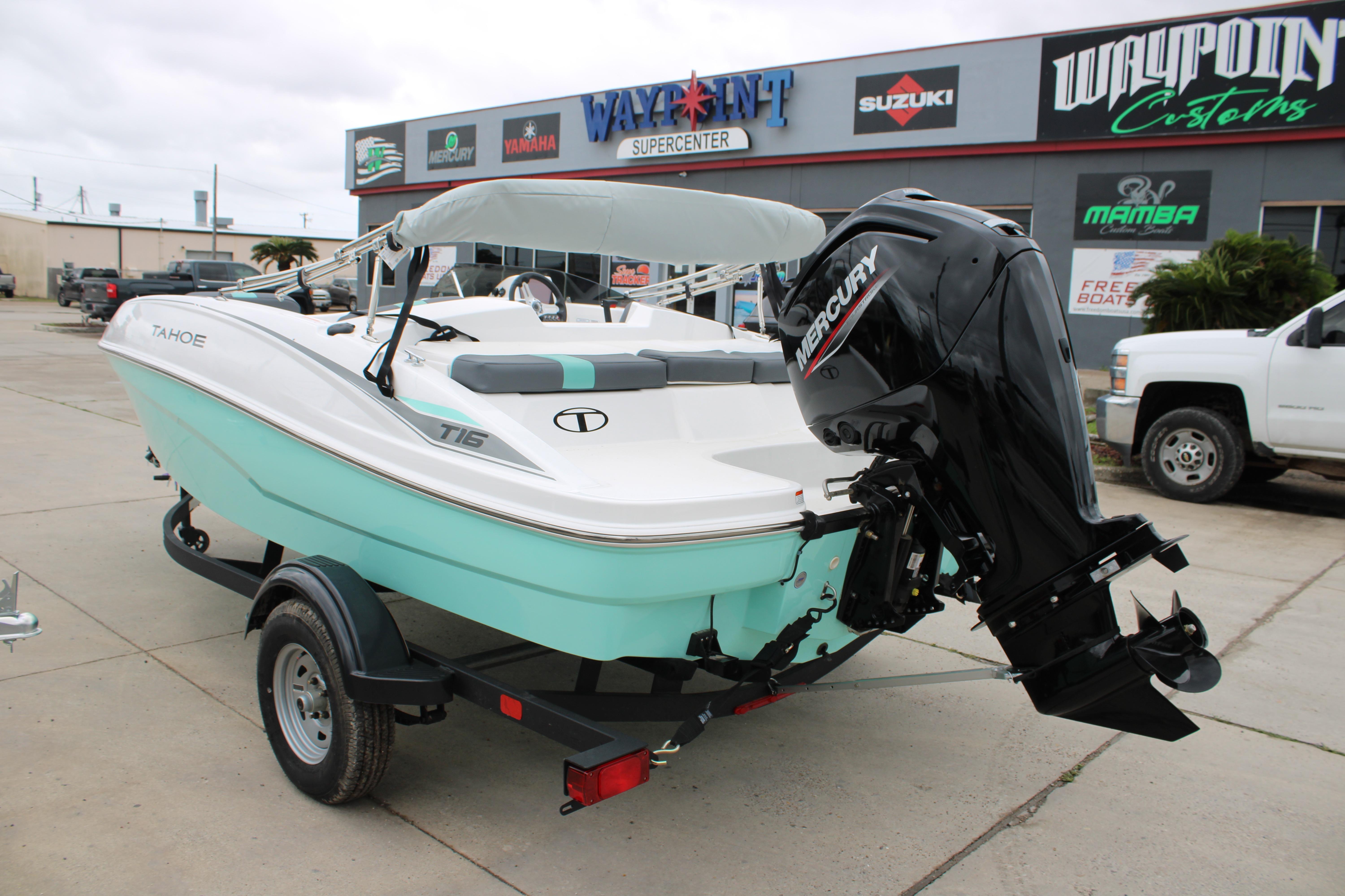 2026 Tahoe T16 boat with Mercury engine on trailer at dealership.