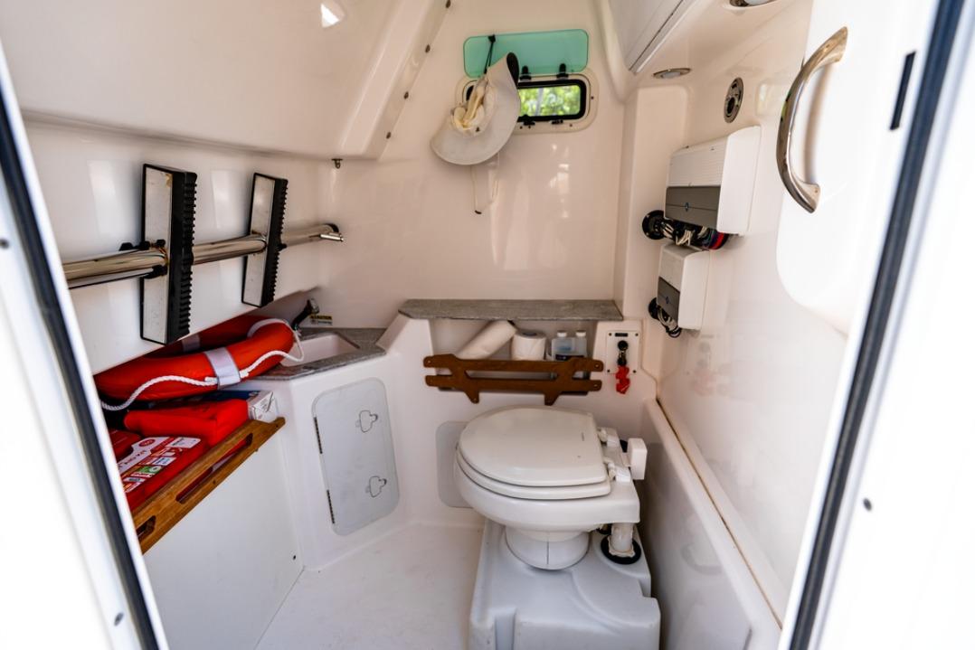 Interior of 2021 Everglades 295 Center Console boat with toilet and storage.