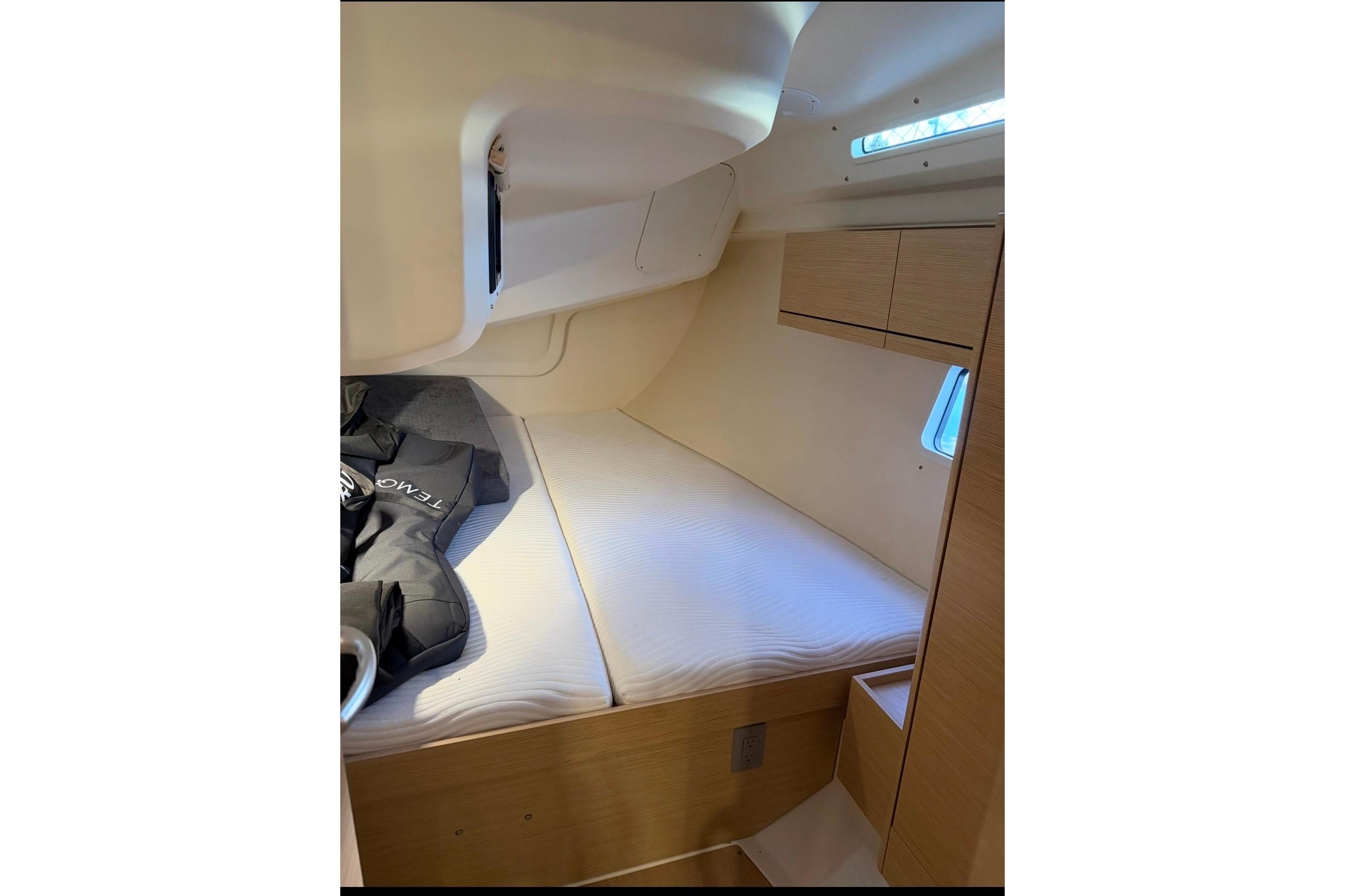 Cozy cabin interior of 2022 Hanse 418 yacht with bed and storage.