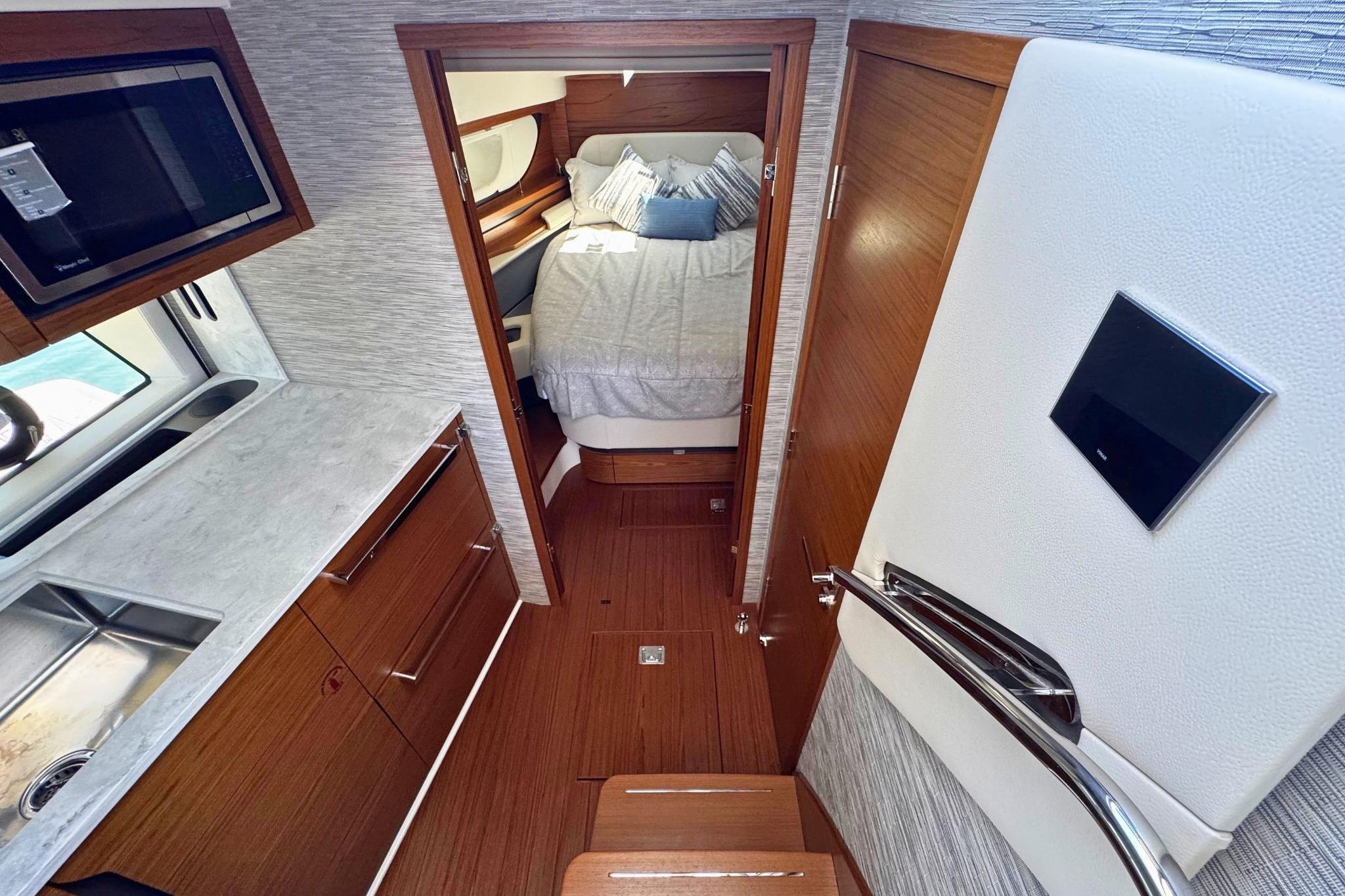 Luxurious interior of 2027 Tiara Yachts 39 LE, featuring modern kitchen and cozy bedroom.