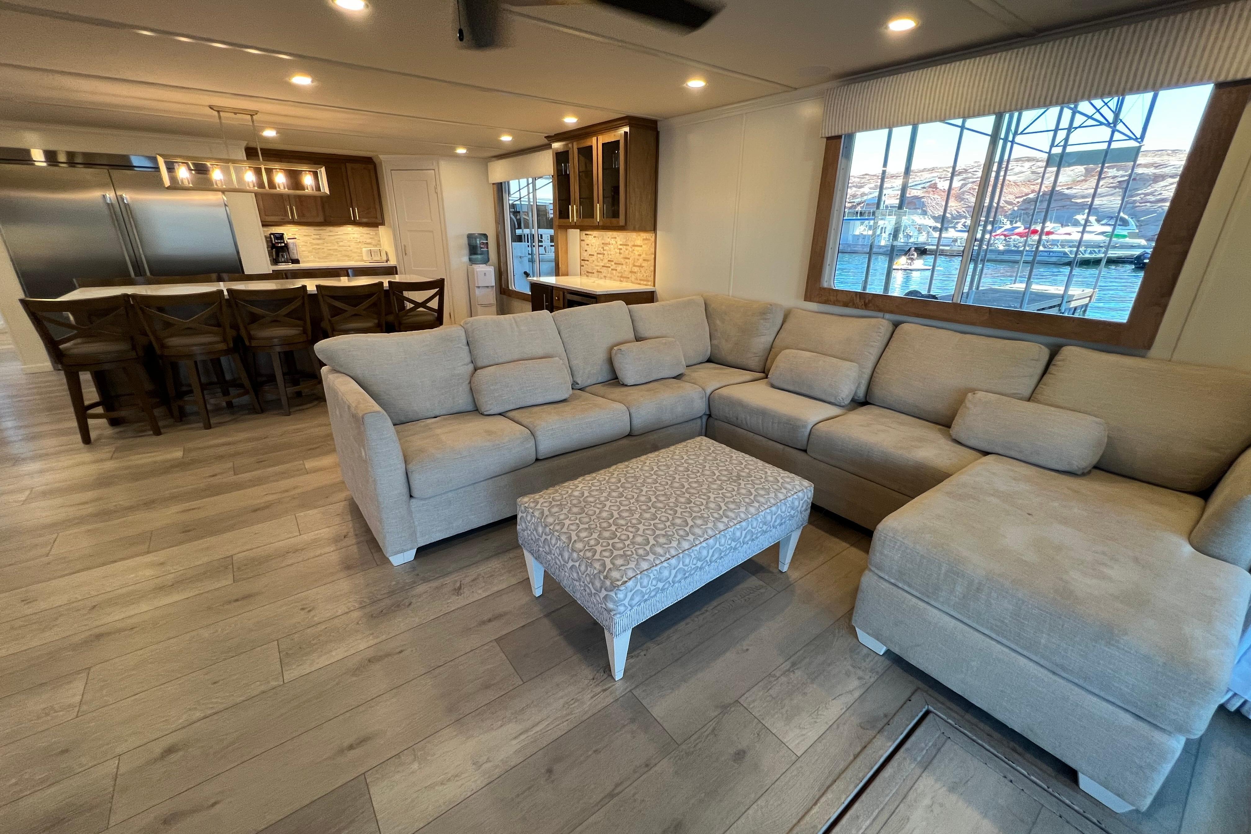 Luxurious Sumerset 2025 houseboat interior with modern kitchen, spacious seating, and scenic water views.