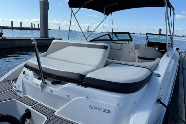 2022 Sea Ray SPX 210 Outboard boat docked, featuring sleek seating and canopy.