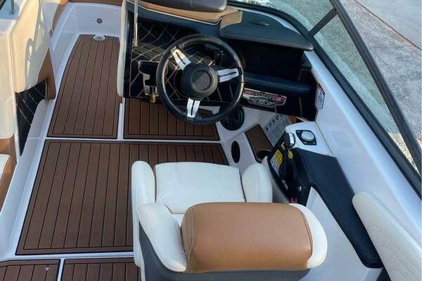 2017 Correct Craft Super Air Nautique GS interior with wood flooring and modern steering wheel.