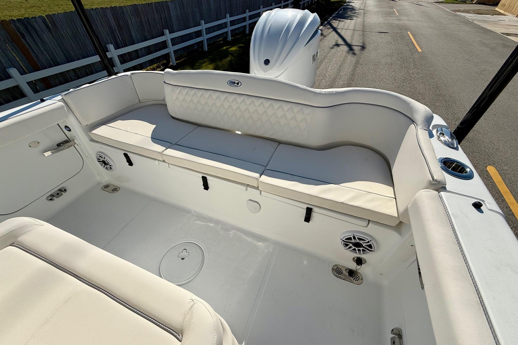 2026 Sea Hunt Ultra 255 SE boat interior with white cushioned seating and speakers.