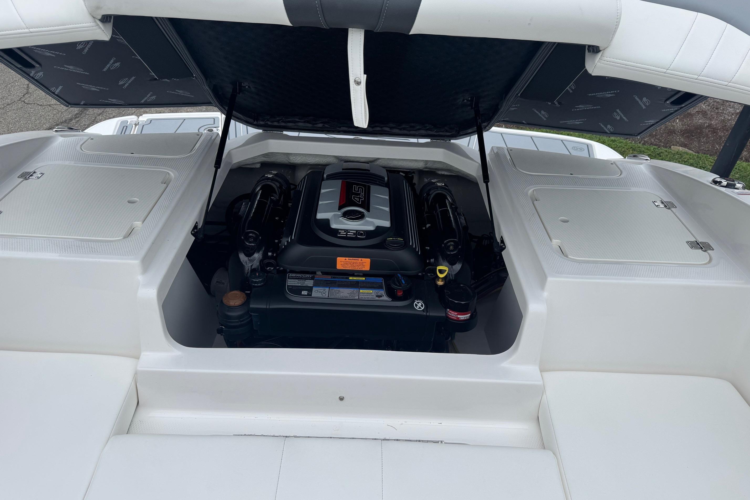 2026 Chaparral 21 SSi boat engine compartment with open hatch, showcasing engine details.