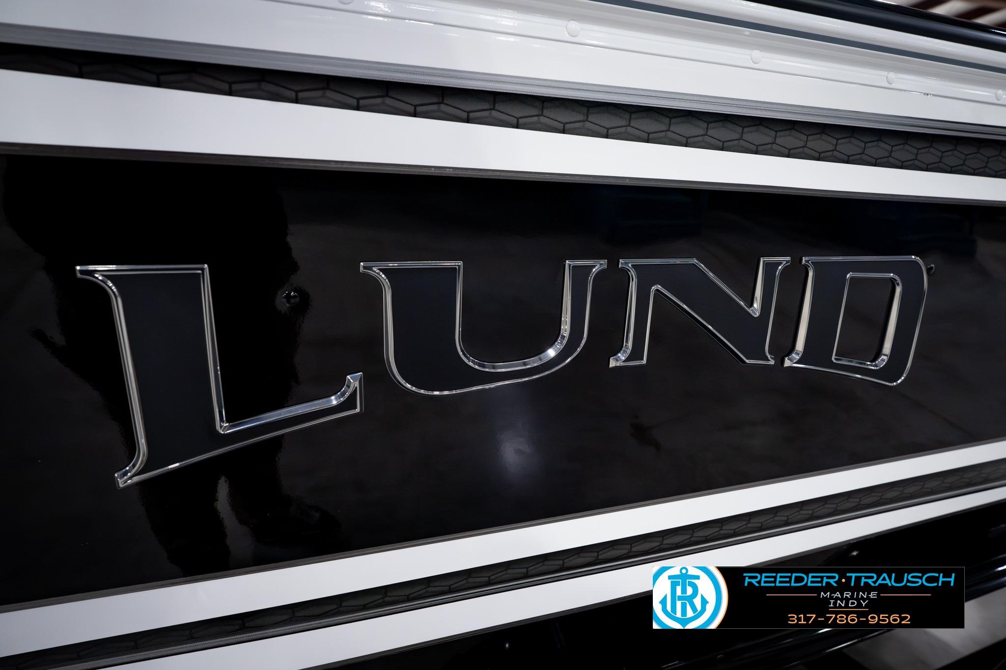 Close-up of 2026 Lund 1875 Impact XS SS boat logo with dealership branding.