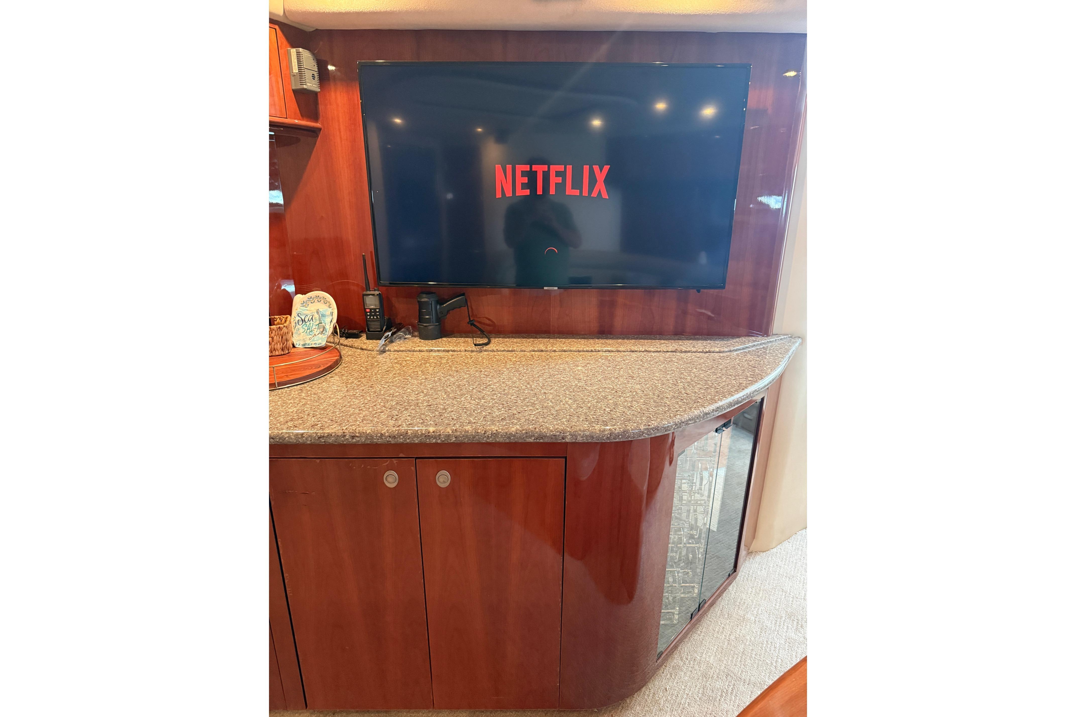 Luxurious interior of 2004 Sea Ray 550 Sundancer with TV displaying Netflix.