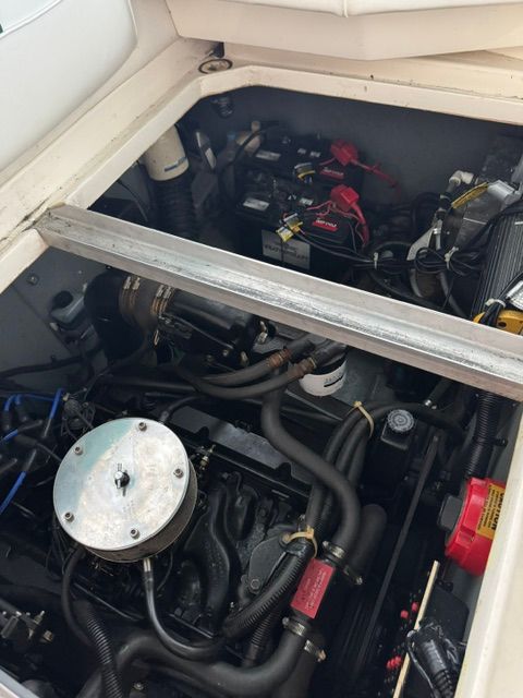 Engine compartment of a 1992 Sea Ray 290 Sundancer with visible batteries and hoses.