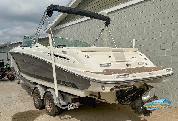 2008 Sea Ray 270 SLX boat on trailer, parked outdoors near a gray building.
