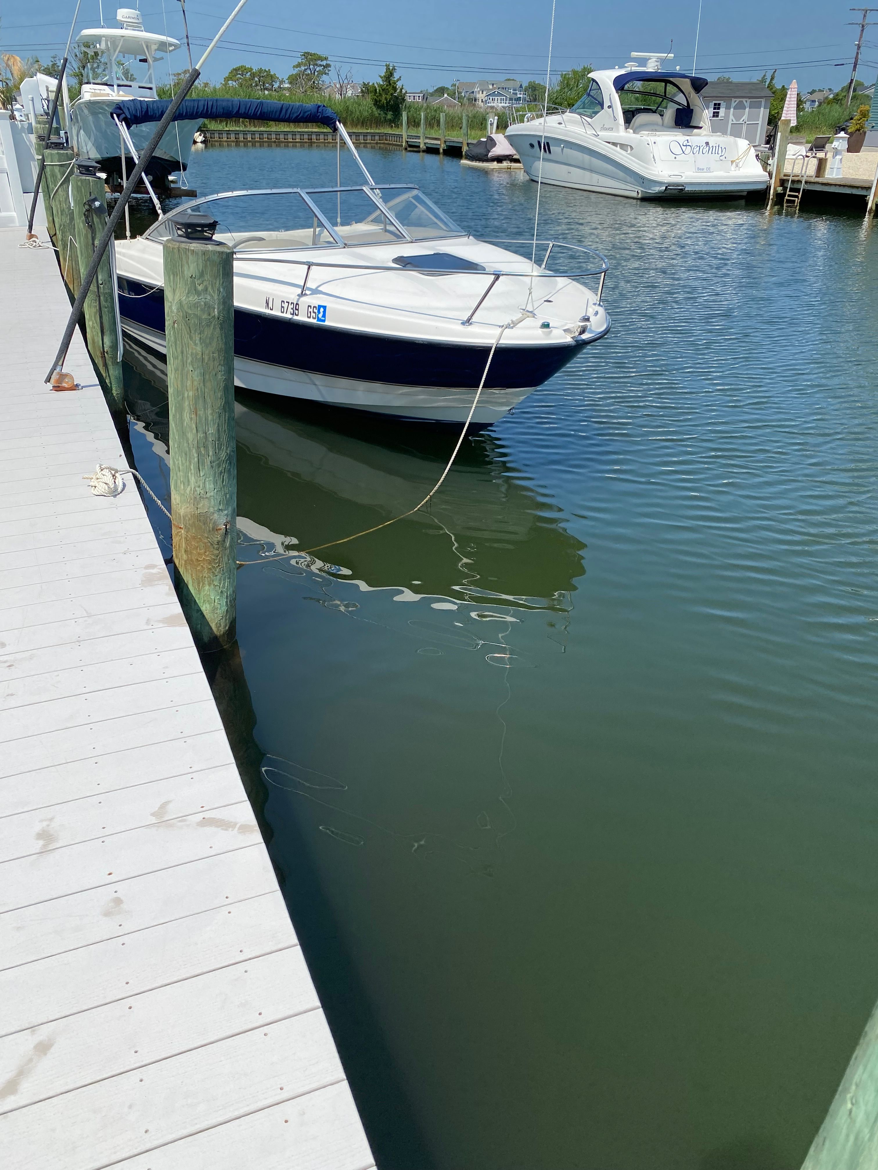 A 2003 Bayliner 2152 is docked in calm water.