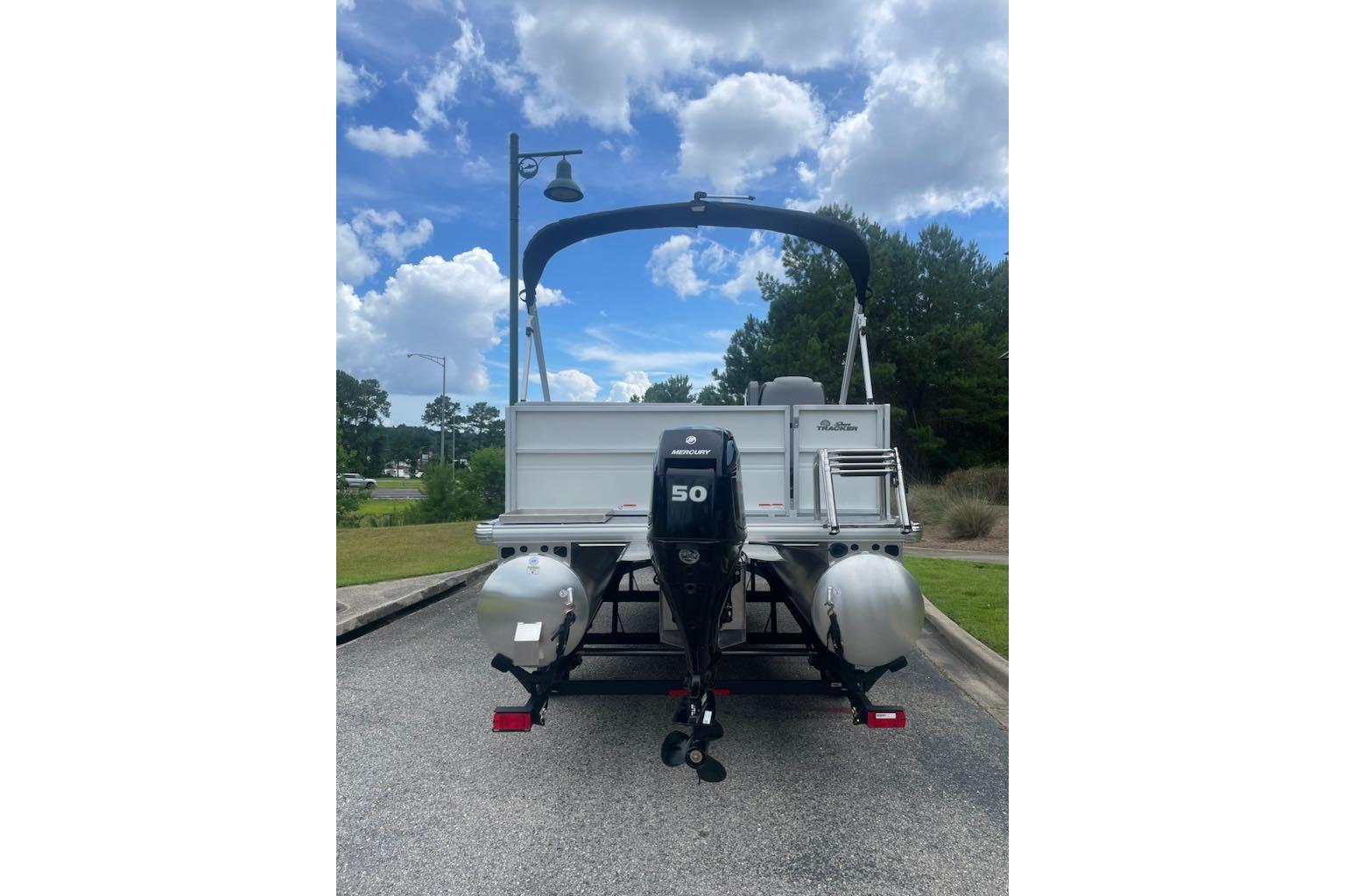 2026 Sun Tracker Party Barge 16 DLX pontoon boat with Mercury 50 engine, parked outdoors.