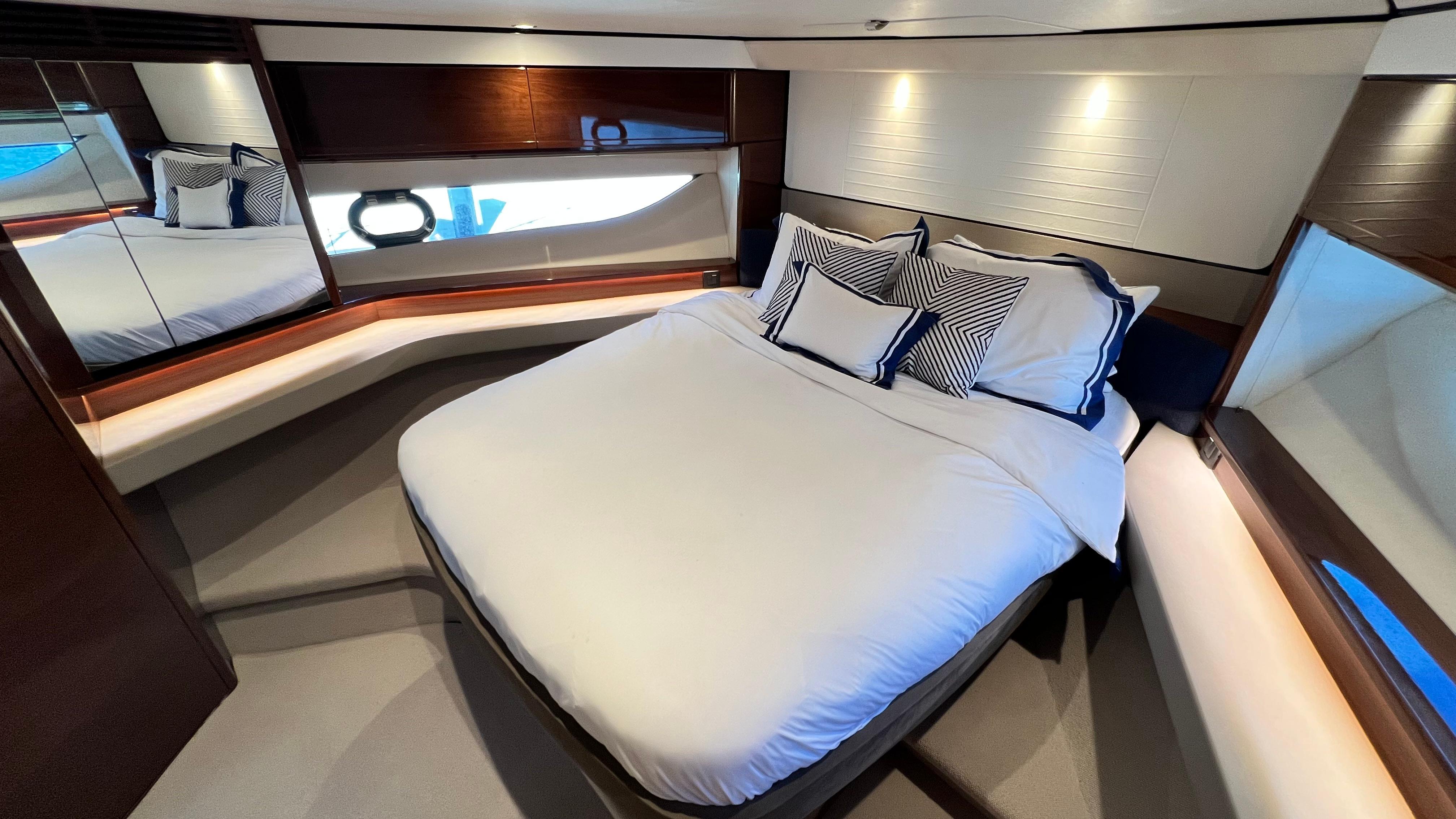 Luxurious cabin interior of 2019 Princess F62 yacht with elegant bedding and modern design.