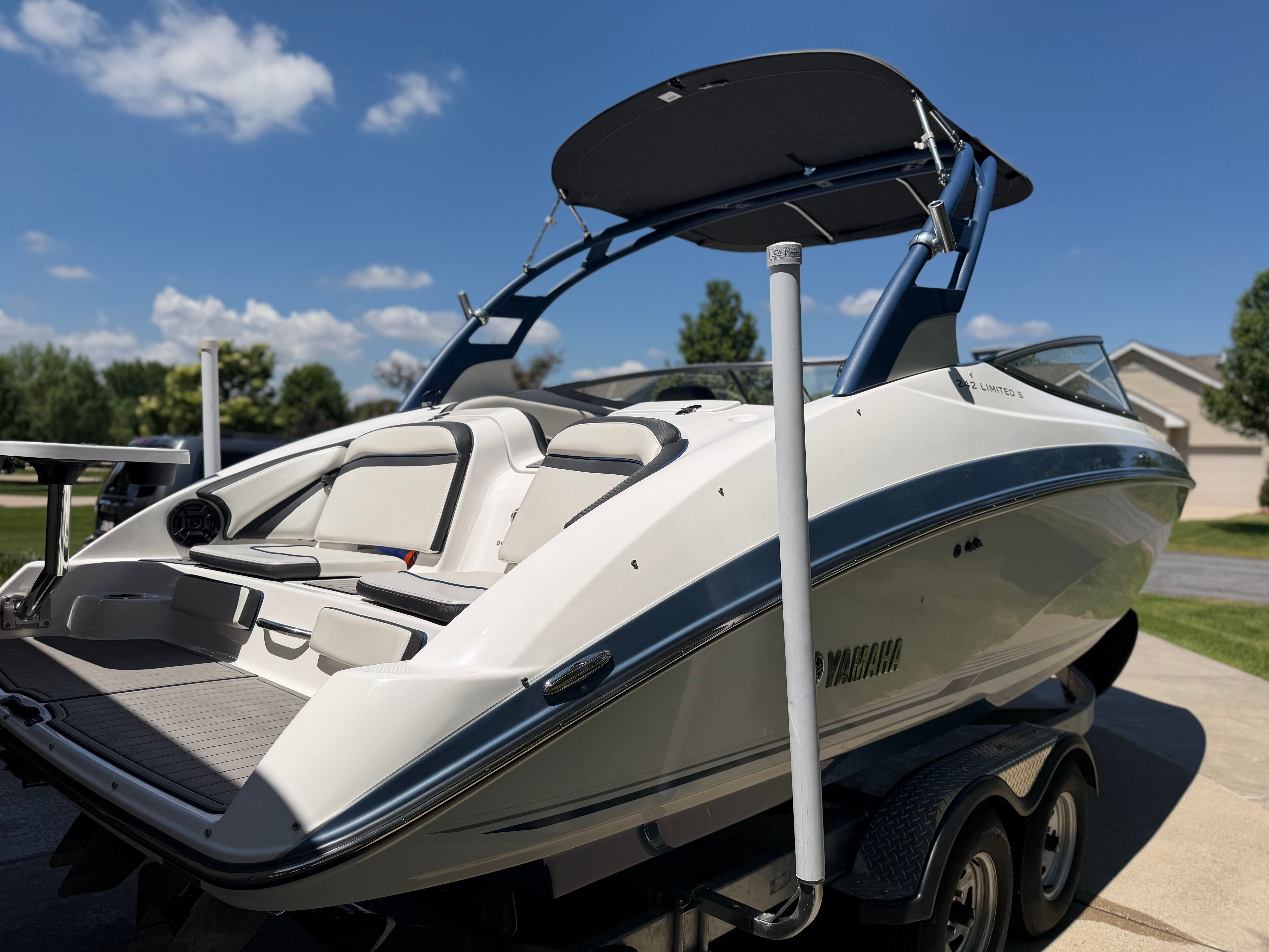 A 2018 Yamaha 242 Limited S boat on a trailer under a blue sky.