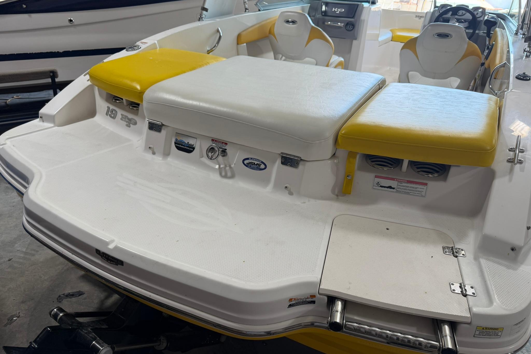 2012 Chaparral 19 Sport H2O boat with yellow and white seating, rear view.
