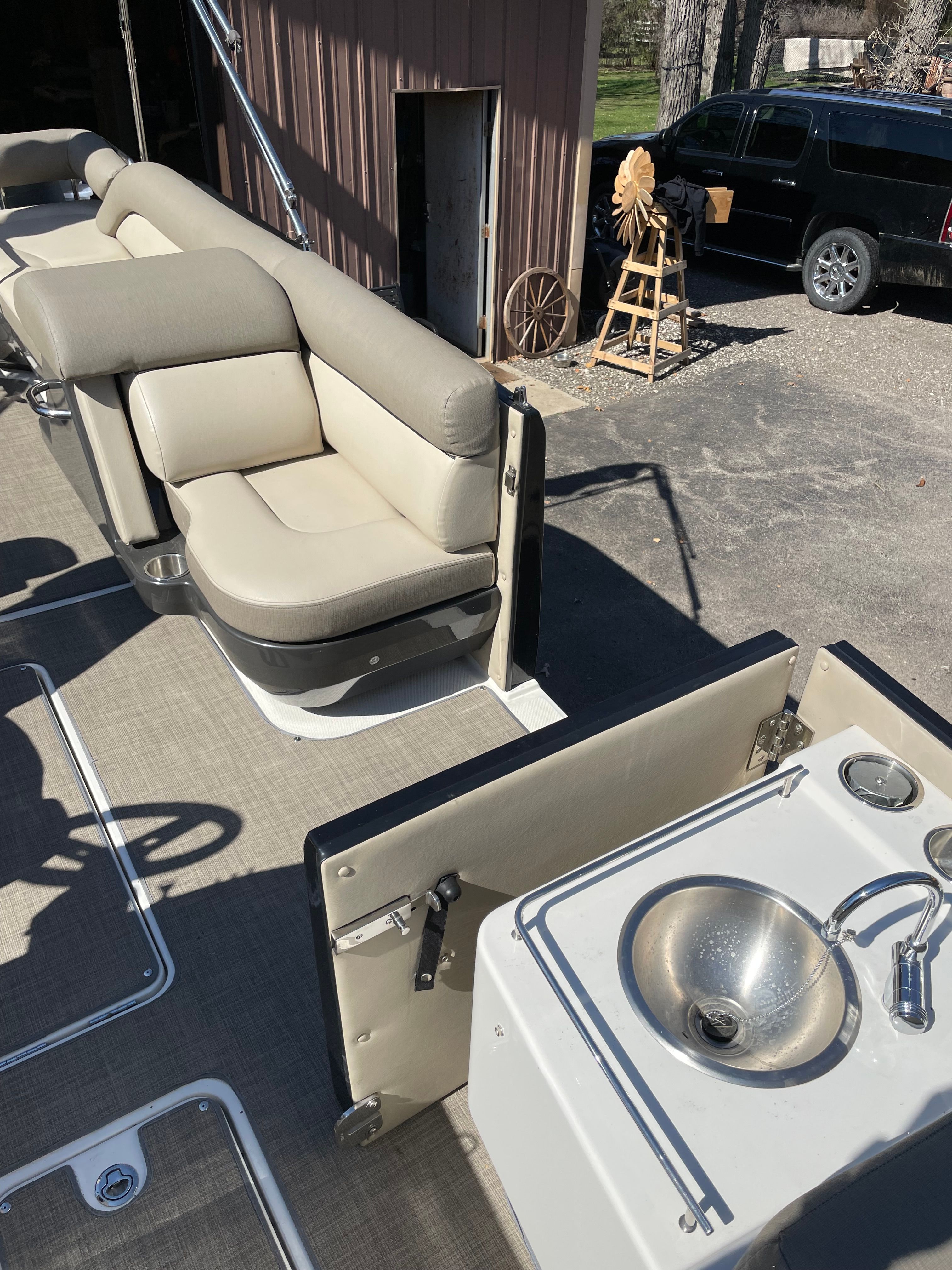The image shows the deck of a 2016 Bayliner Element XR7 with seating and a sink.