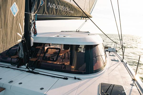 2025 Nautitech 40 Open catamaran sailing on the ocean at sunset.