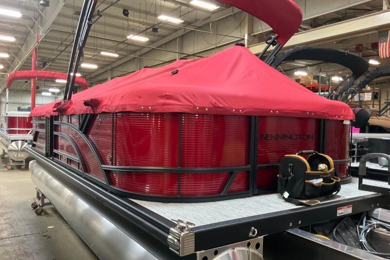 2026 Bennington 22 SSRSF pontoon boat with red cover in a warehouse setting.