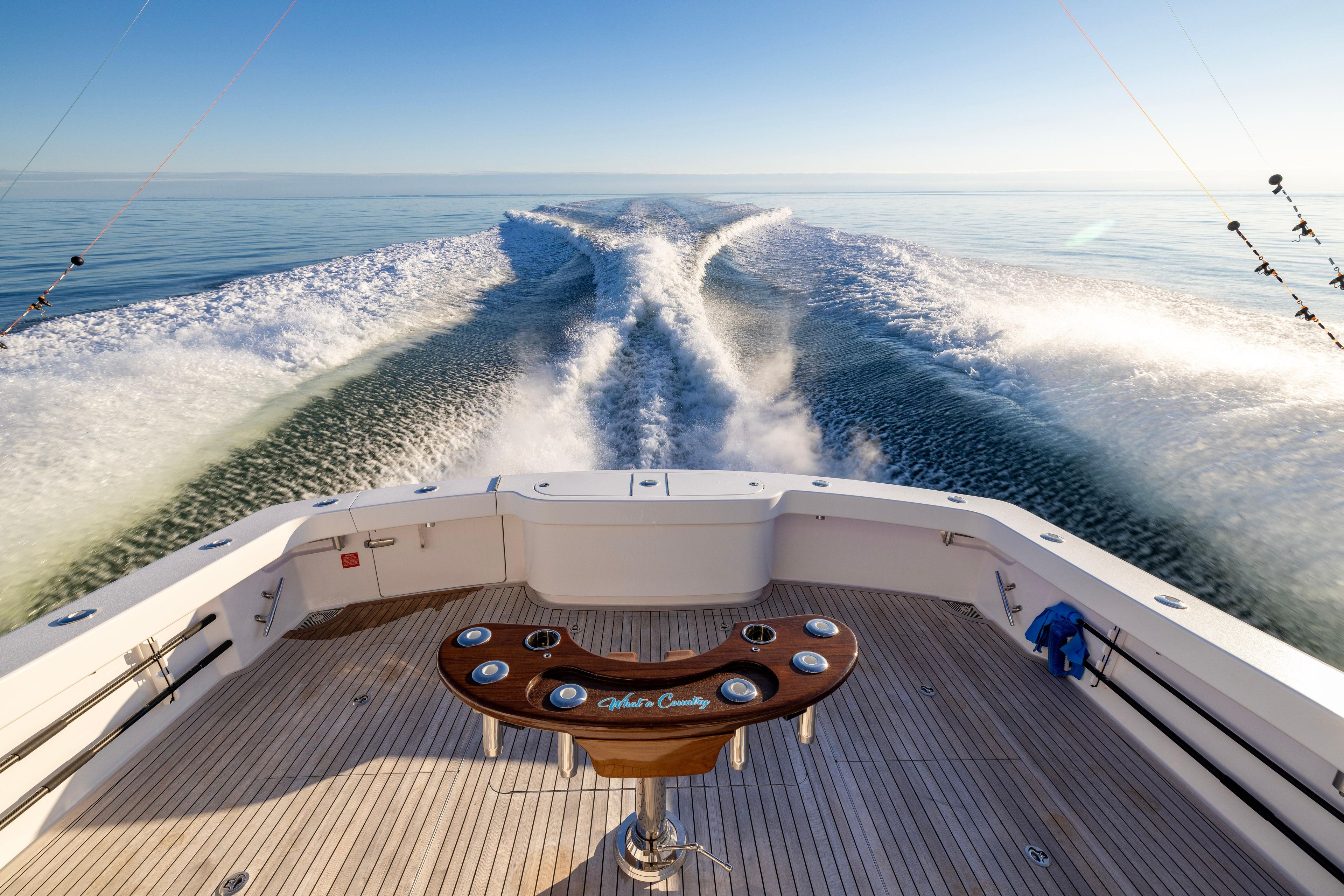 2022 Viking 54 Sport Coupe cruising, leaving a wake on calm ocean waters.