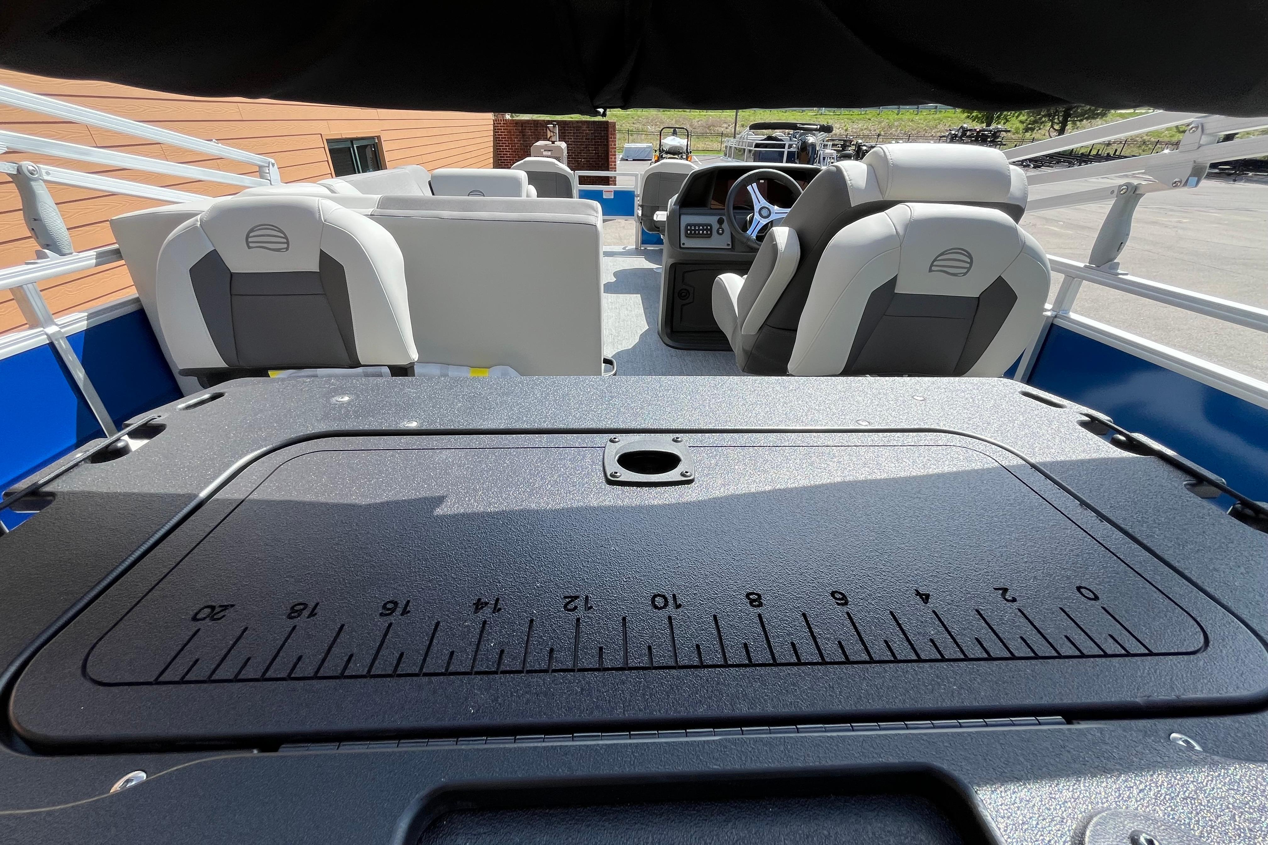 2026 Sun Tracker Fishin' Barge 20 DLX interior with seating and measurement panel.