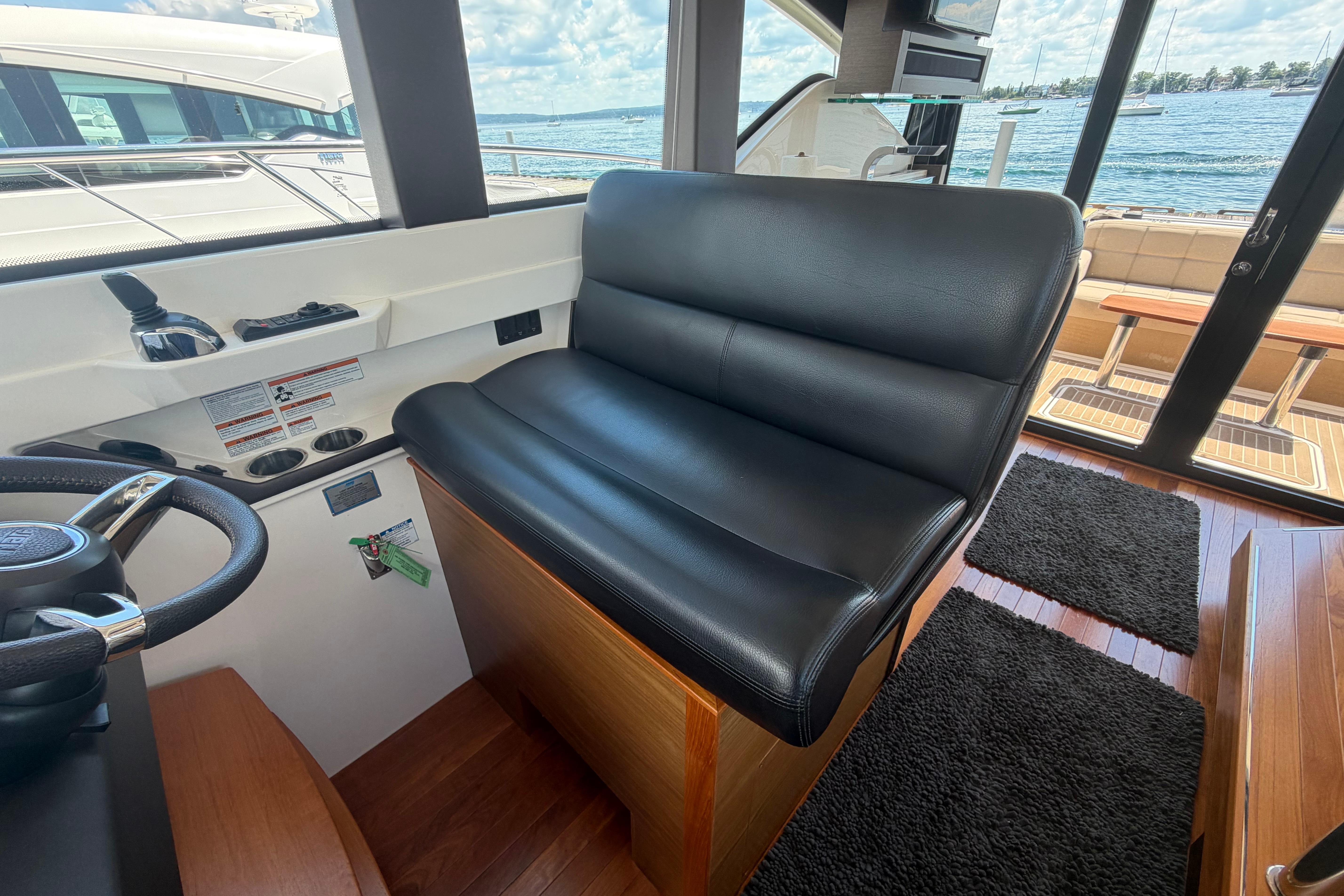 Interior of 2016 Tiara Yachts C39 Coupe with black leather seating and steering wheel.