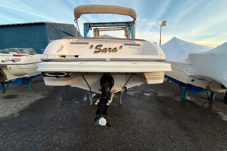 1999 Ebbtide 2300 Bow Rider boat named "Sara" on a trailer at a marina.