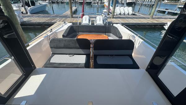 2025 Nimbus T11 boat interior with seating and table, docked at marina.