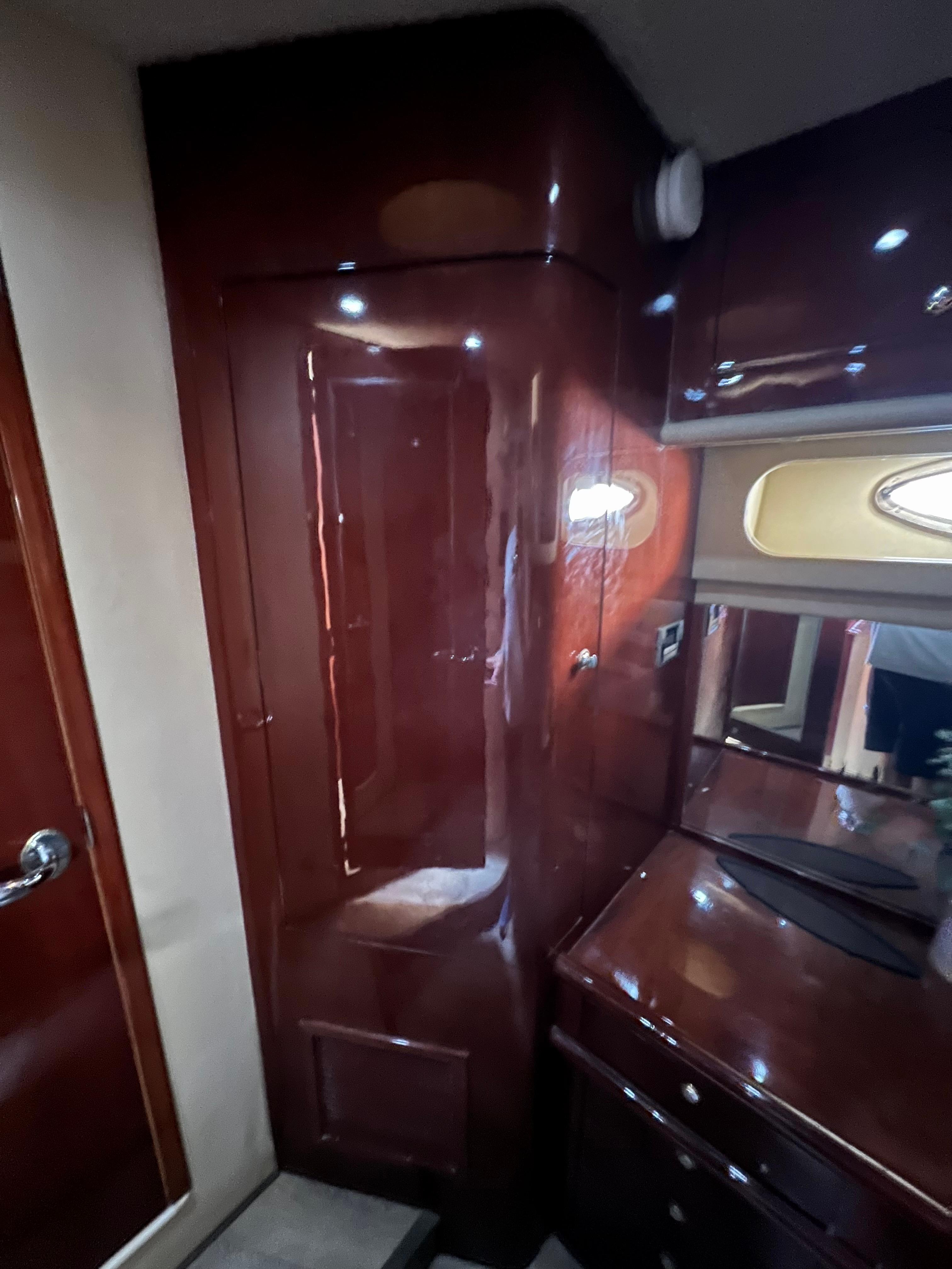 Interior of 2002 Sea Ray 560 Sedan Bridge with glossy wood finish and cabinetry.