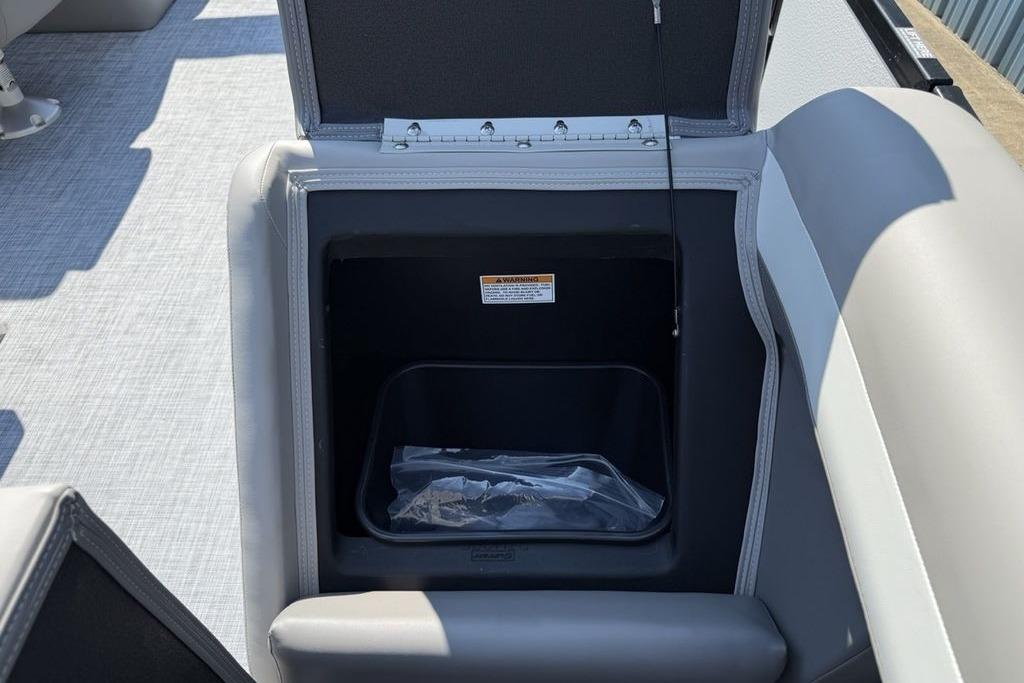 Open storage compartment in 2026 Premier 220 Sunscape RF boat, featuring gray upholstery.