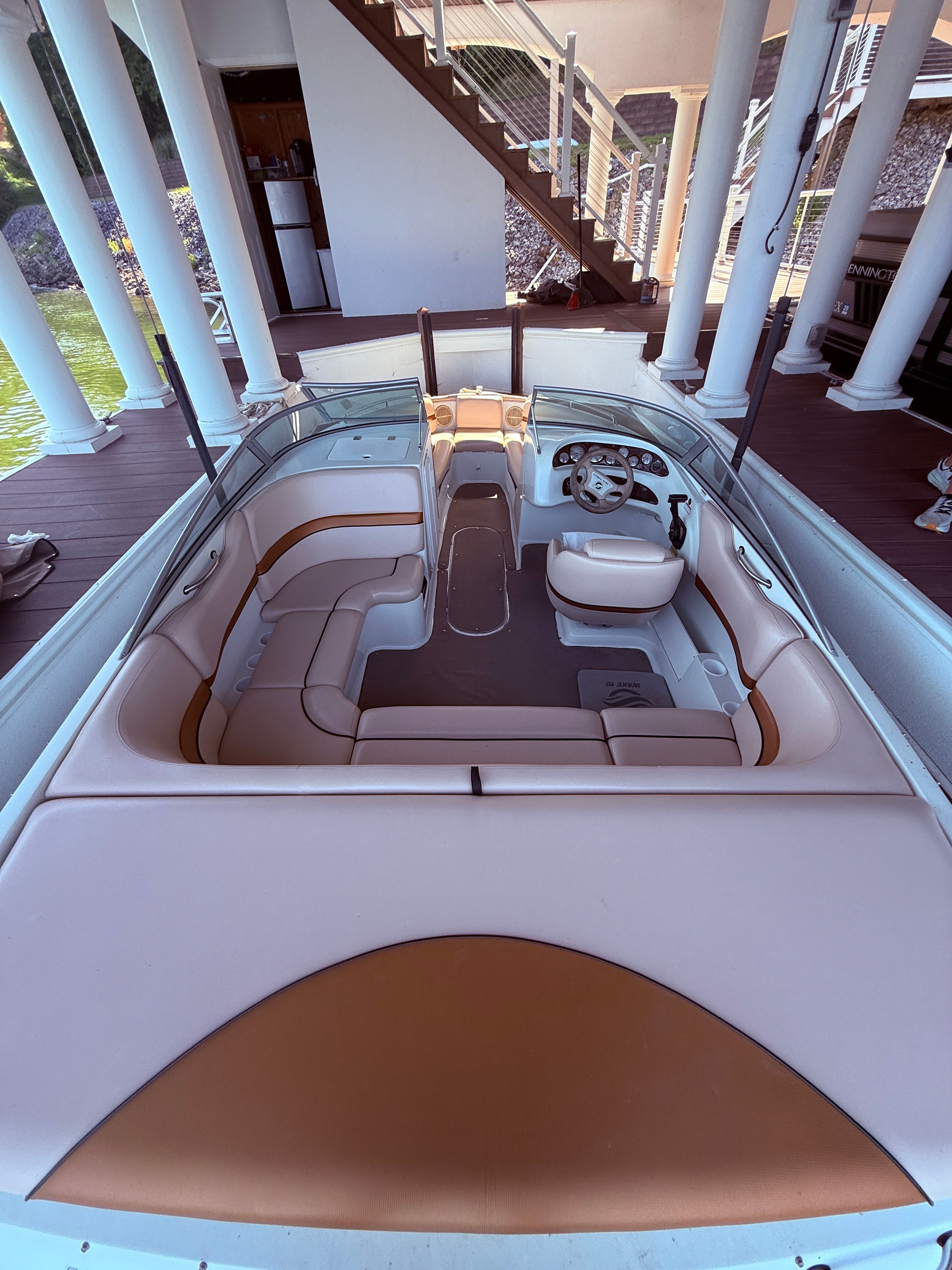 Interior view of a 2000 Starcraft Next Star 19 boat with beige seating and steering wheel.