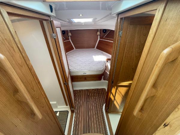2024 Back Cove 34O cabin interior with wooden finishes and a cozy bed.