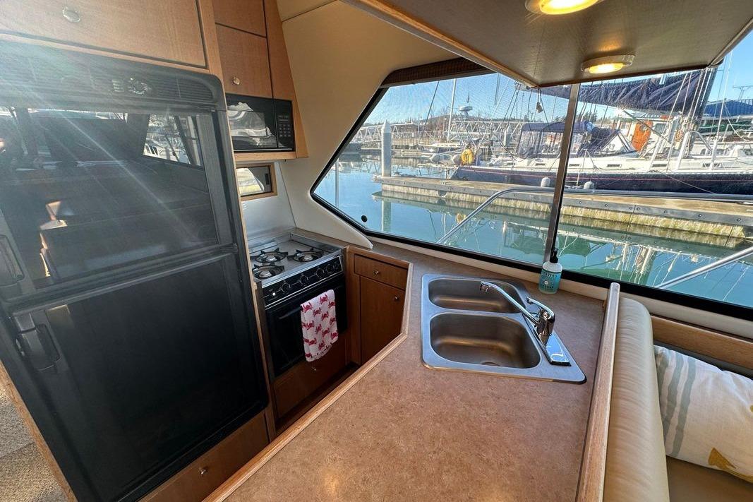 Interior of 2000 Bayliner 4087 Aft Cabin Motoryacht with kitchen and marina view.