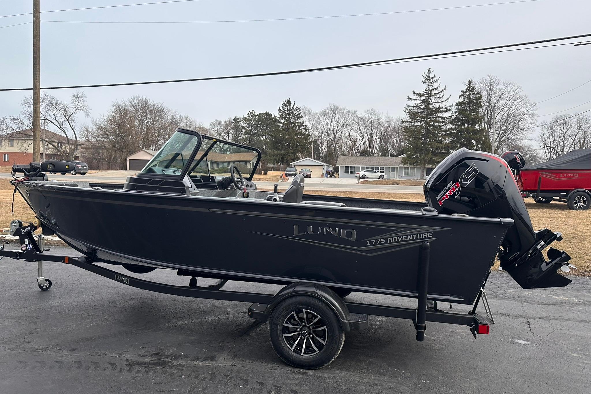 2026 Lund 1775 Adventure Sport boat on trailer, parked outdoors.