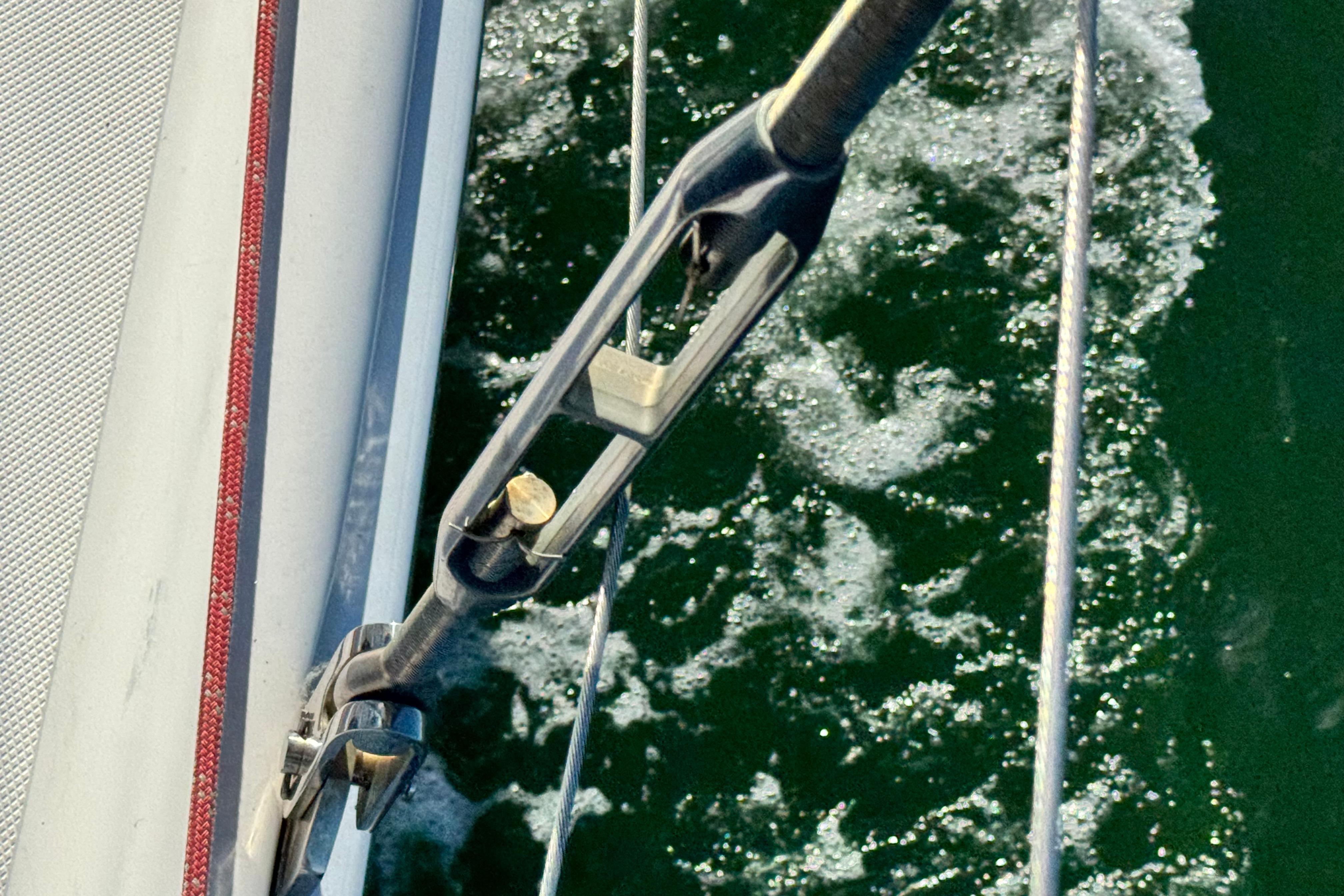 Close-up of a 2008 Hunter 49 sailboat rigging over green water.
