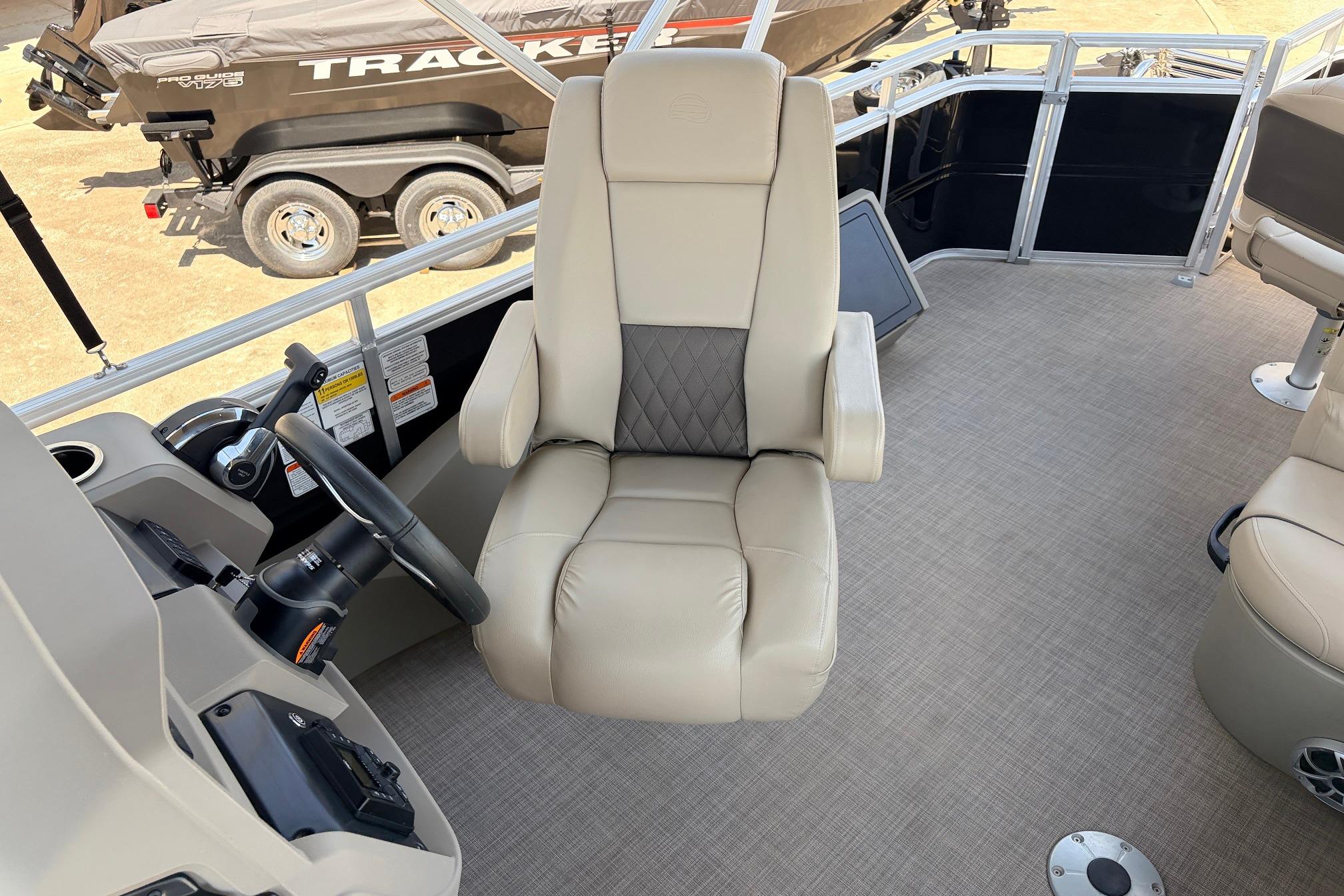 2024 Sun Tracker SportFish 22 XP3 boat interior with captain's chair and steering wheel.