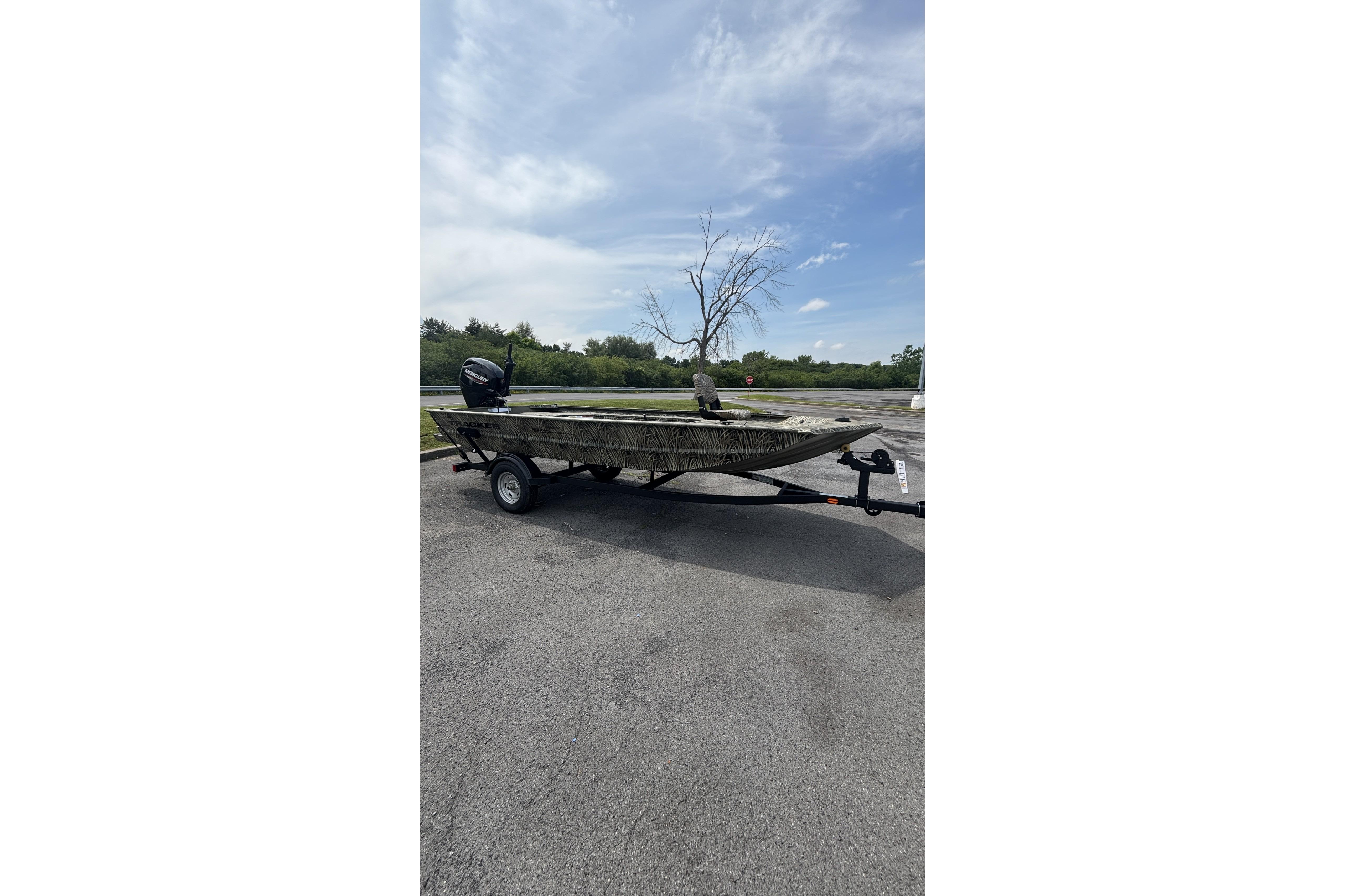 2026 Tracker Grizzly 1654 T Sportsman boat on trailer, parked outdoors under blue sky.