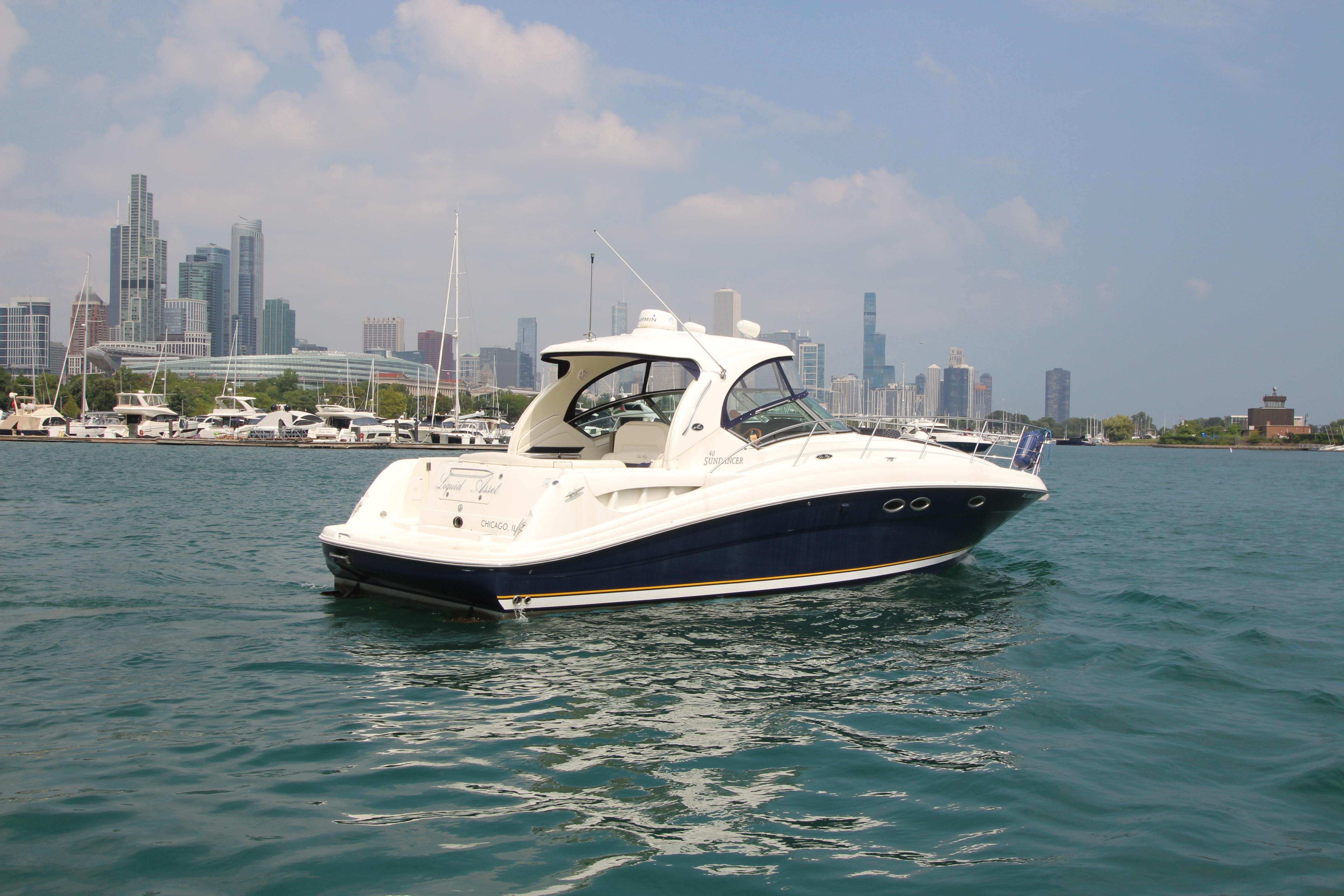 2004 Sea Ray 40 Sundancer yacht on water with city skyline in background.
