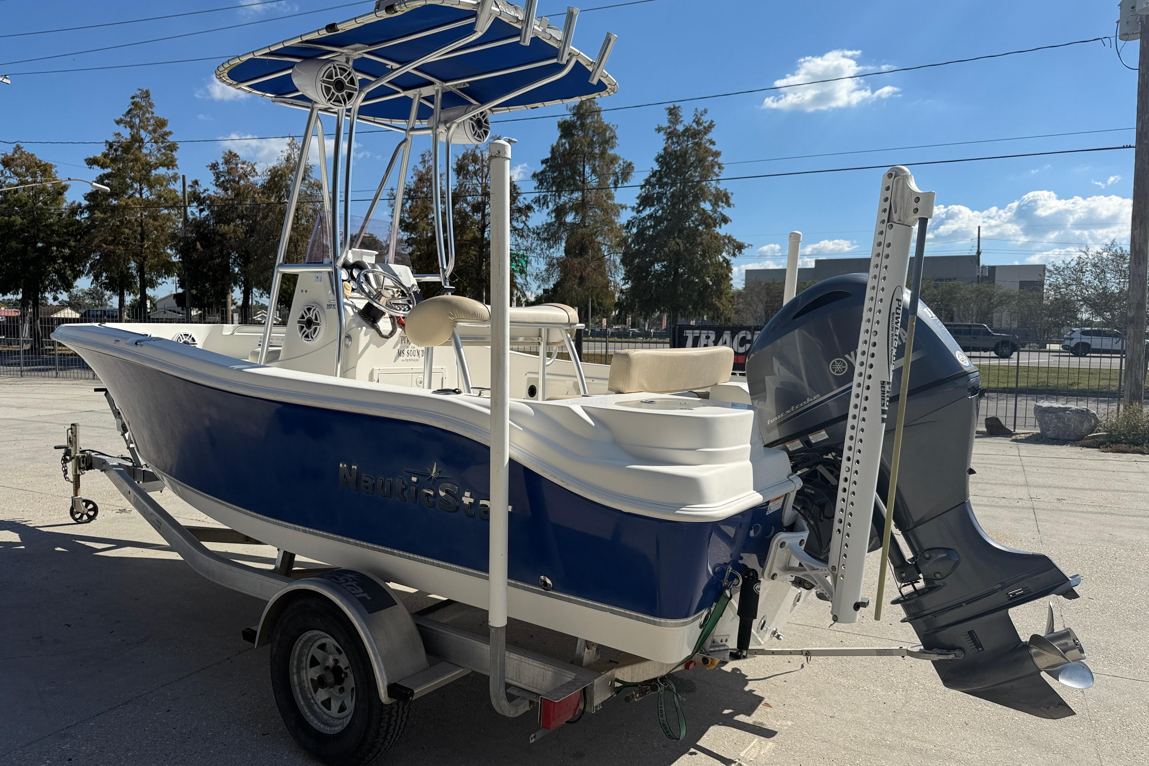 2019 NauticStar 19 XS boat with blue hull and outboard motor on trailer.