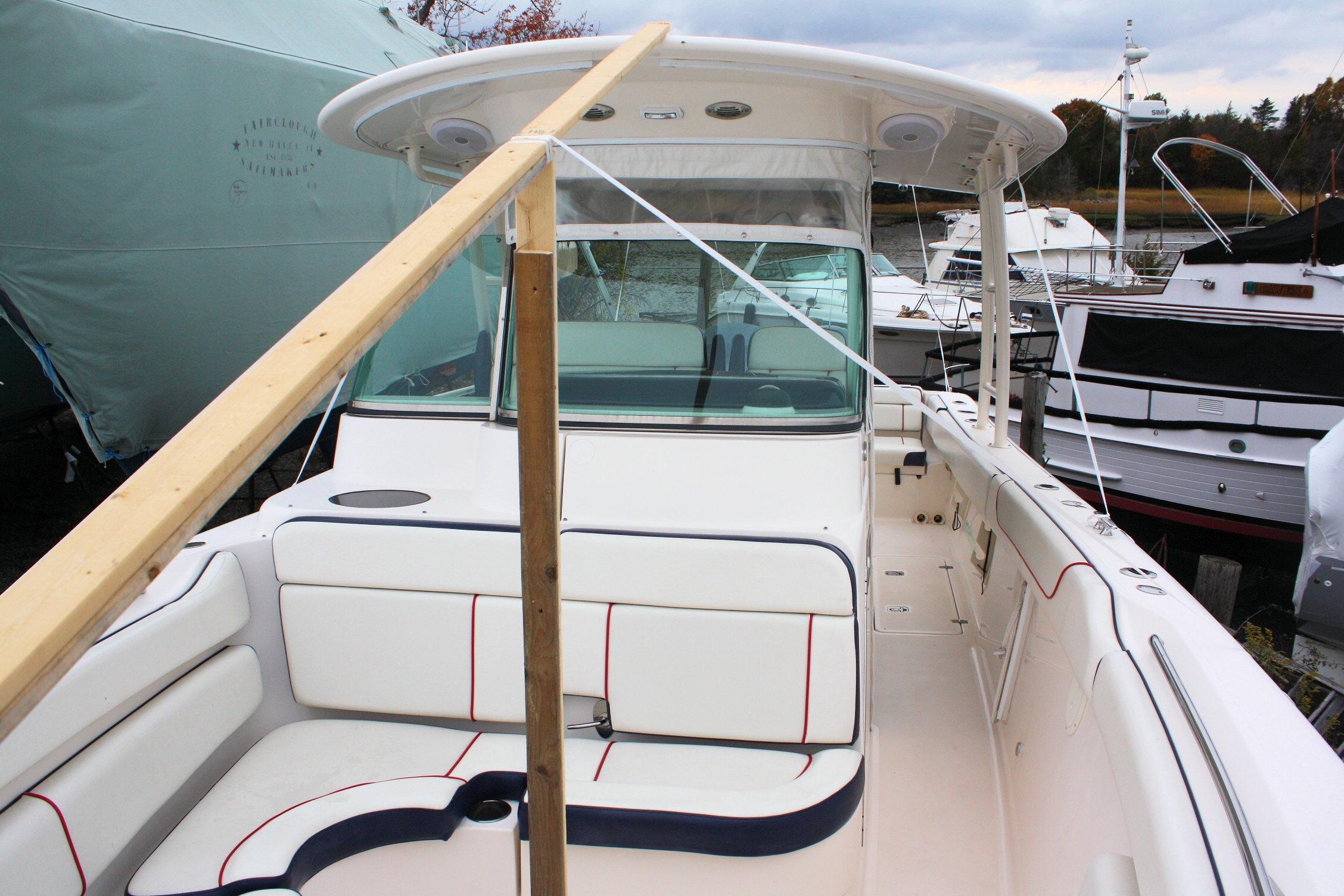2013 Pursuit ST 310 Sport boat with white seating and protective cover.