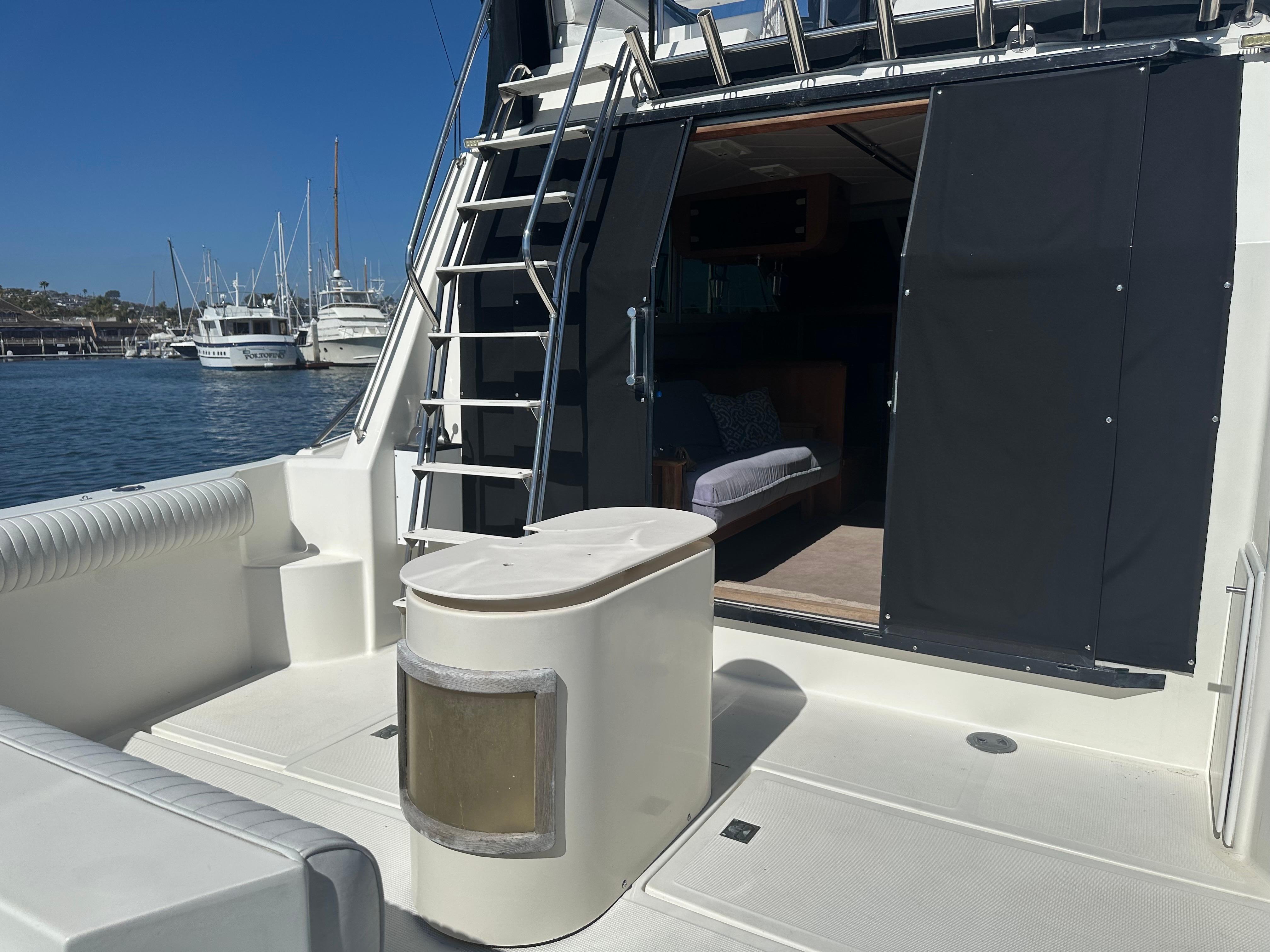 1991 Symbol 39 Sedan Sportfisher boat deck with ladder and open cabin door.