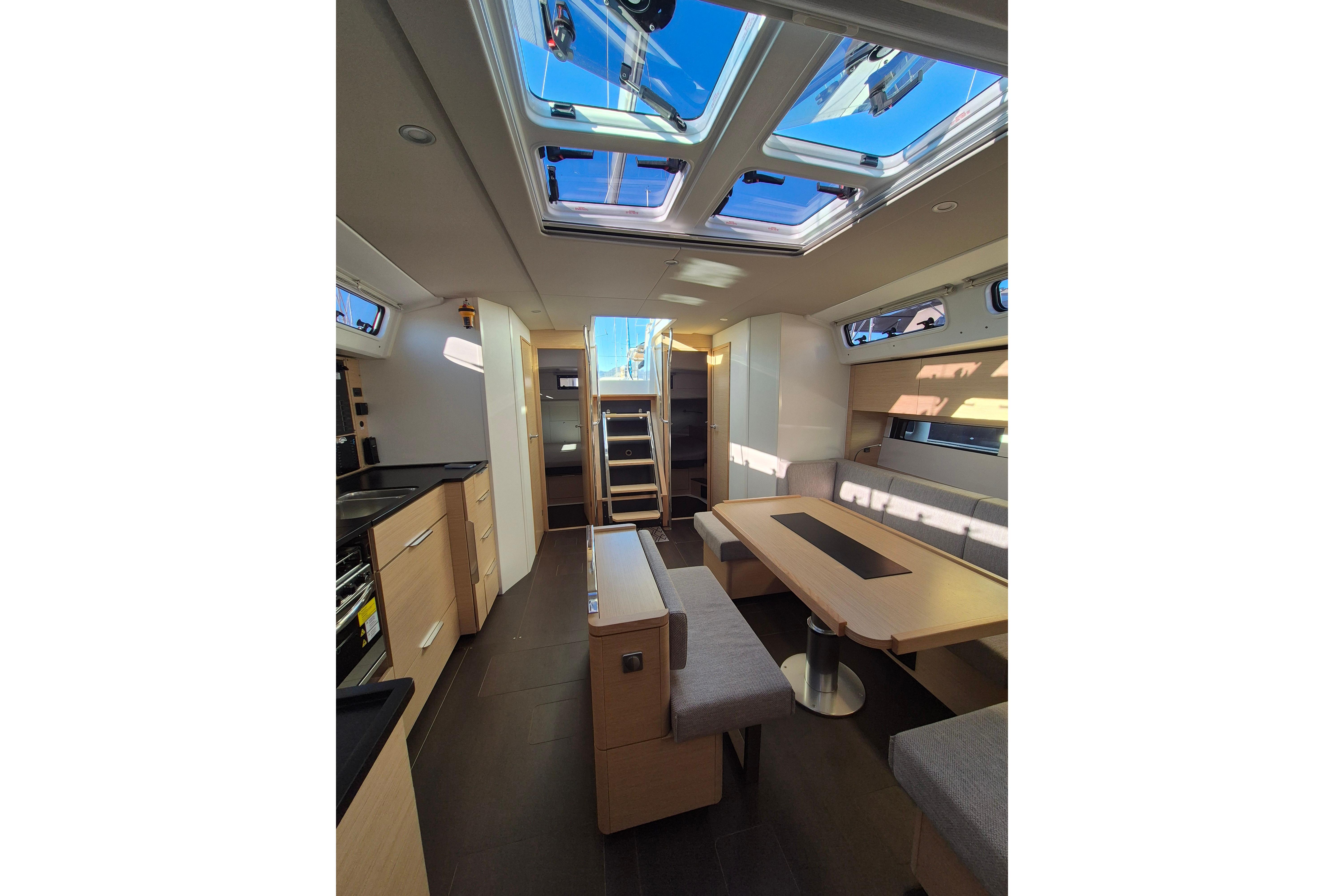 Luxurious interior of 2024 Hanse 460 yacht with modern kitchen and seating area.