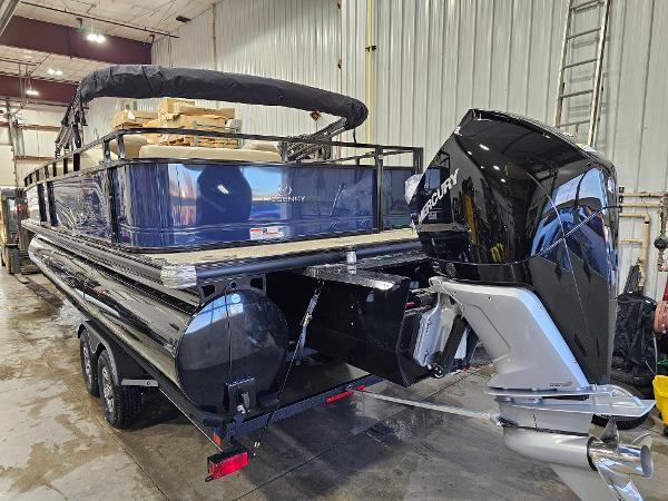 2024 Regency 250 DL3 pontoon boat with Mercury outboard motor in a warehouse.