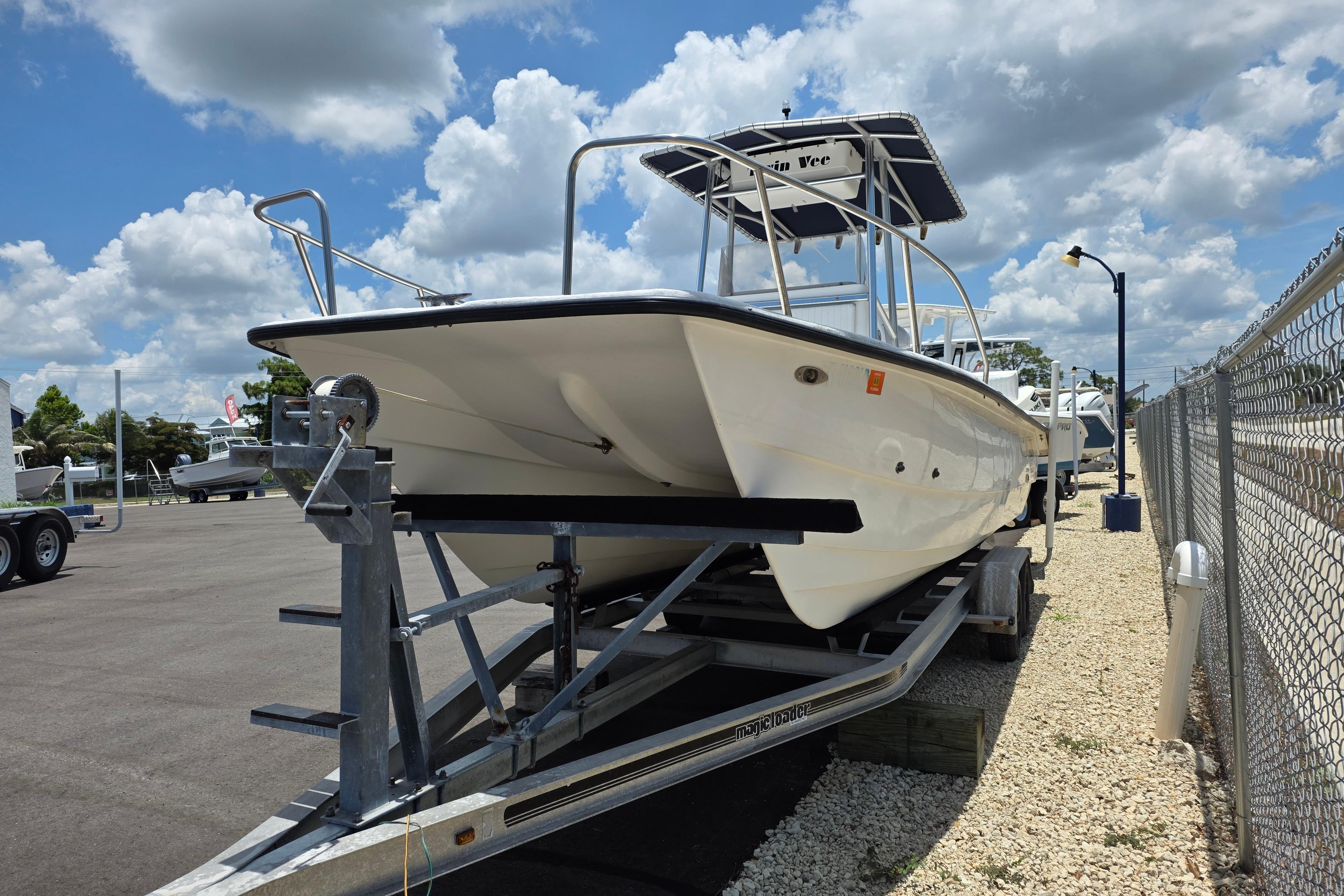 1999 Twin Vee Awesome 22 boat on trailer under a partly cloudy sky.