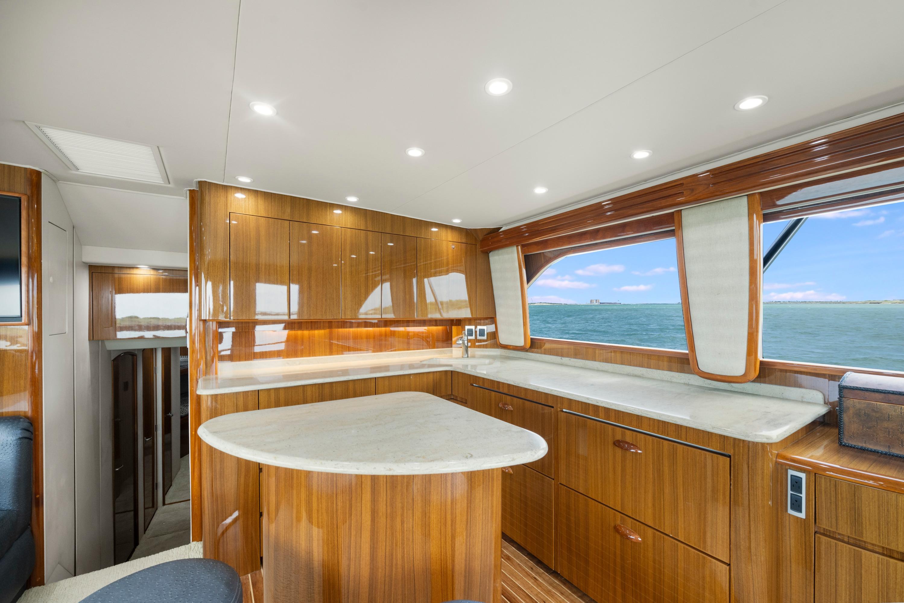 Luxurious interior of 2009 Viking 50 Convertible yacht with wooden cabinetry and ocean view.