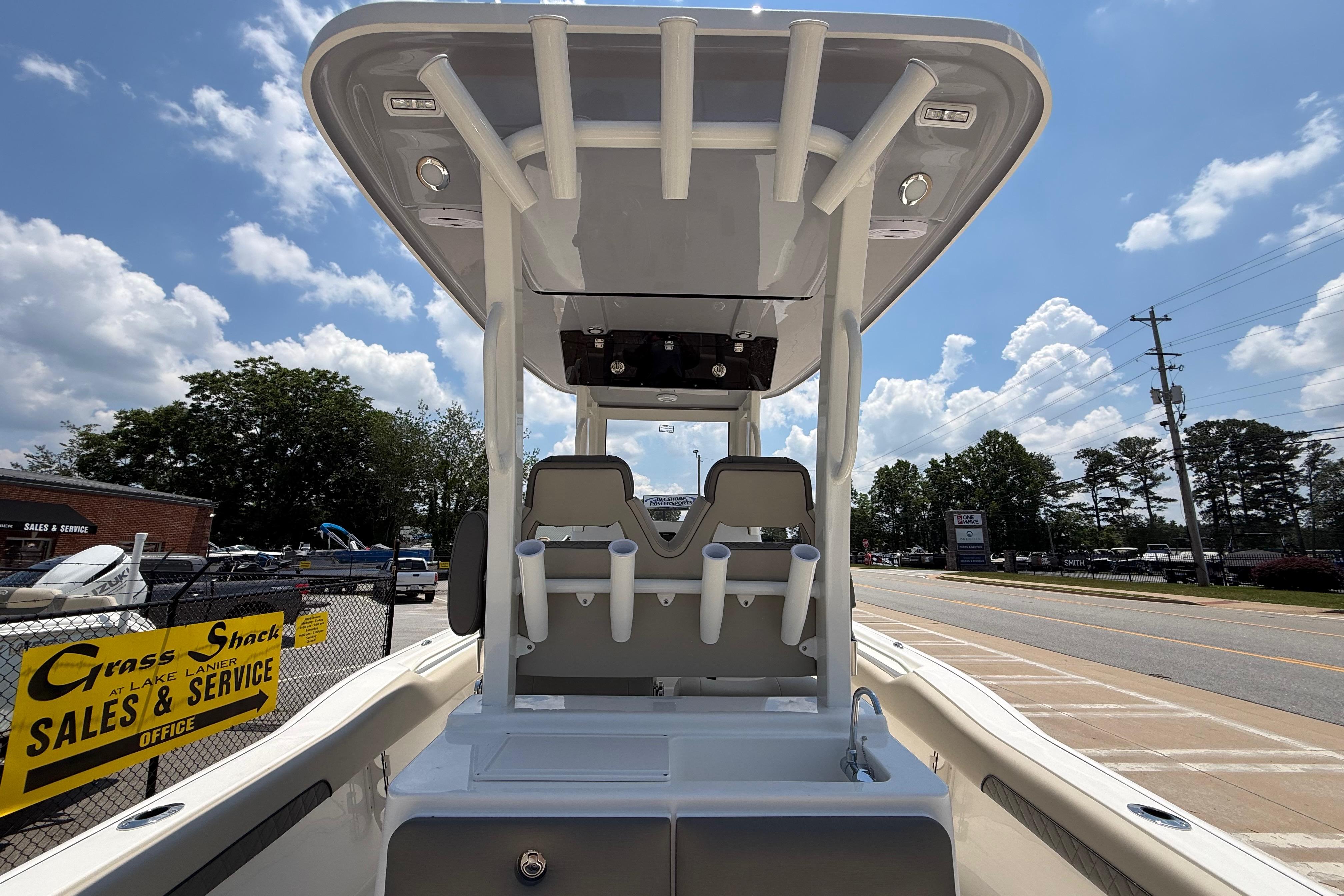 2027 Key West 249 FS boat at dealership, showcasing seating and rod holders under a clear sky.
