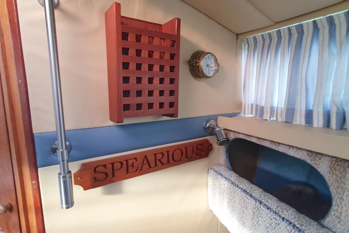 Interior of 1989 Fairey Spearfish MKIII boat with nautical decor and striped curtains.