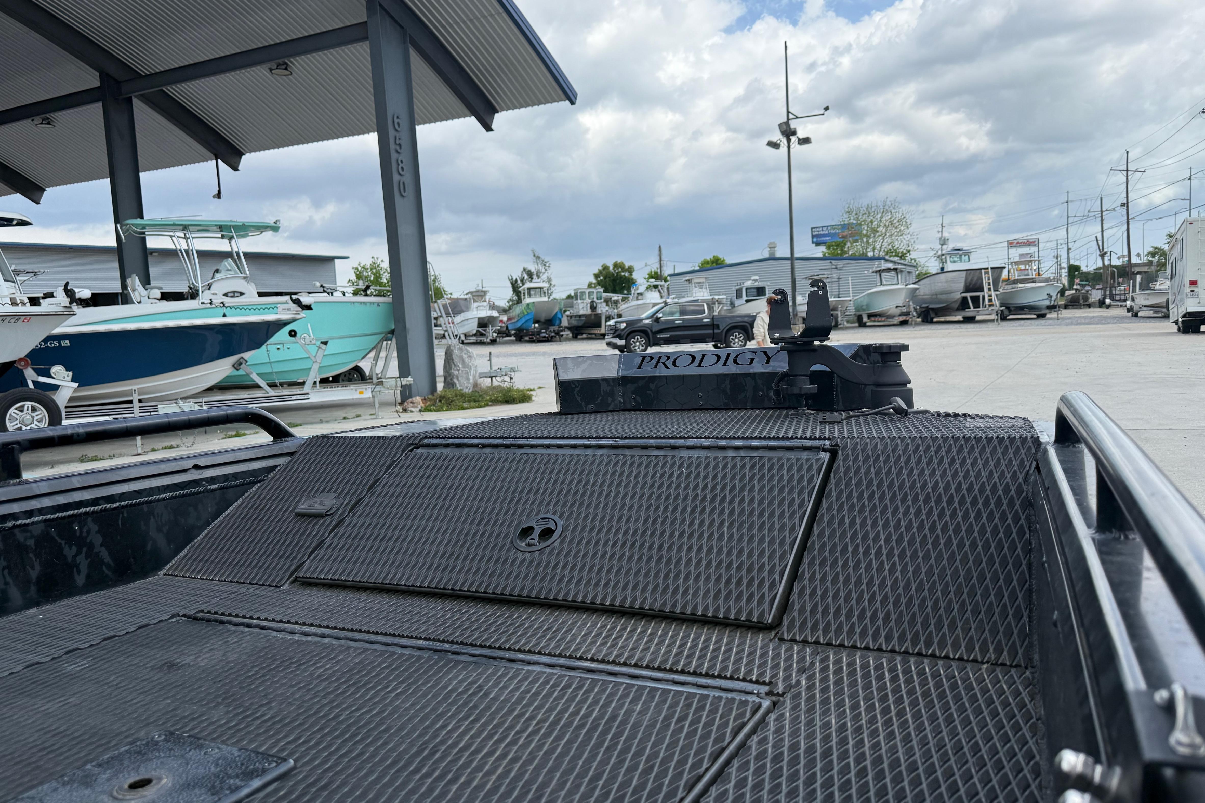 Outdoor display of 2024 Prodigy 17 boat at a dealership with other boats.